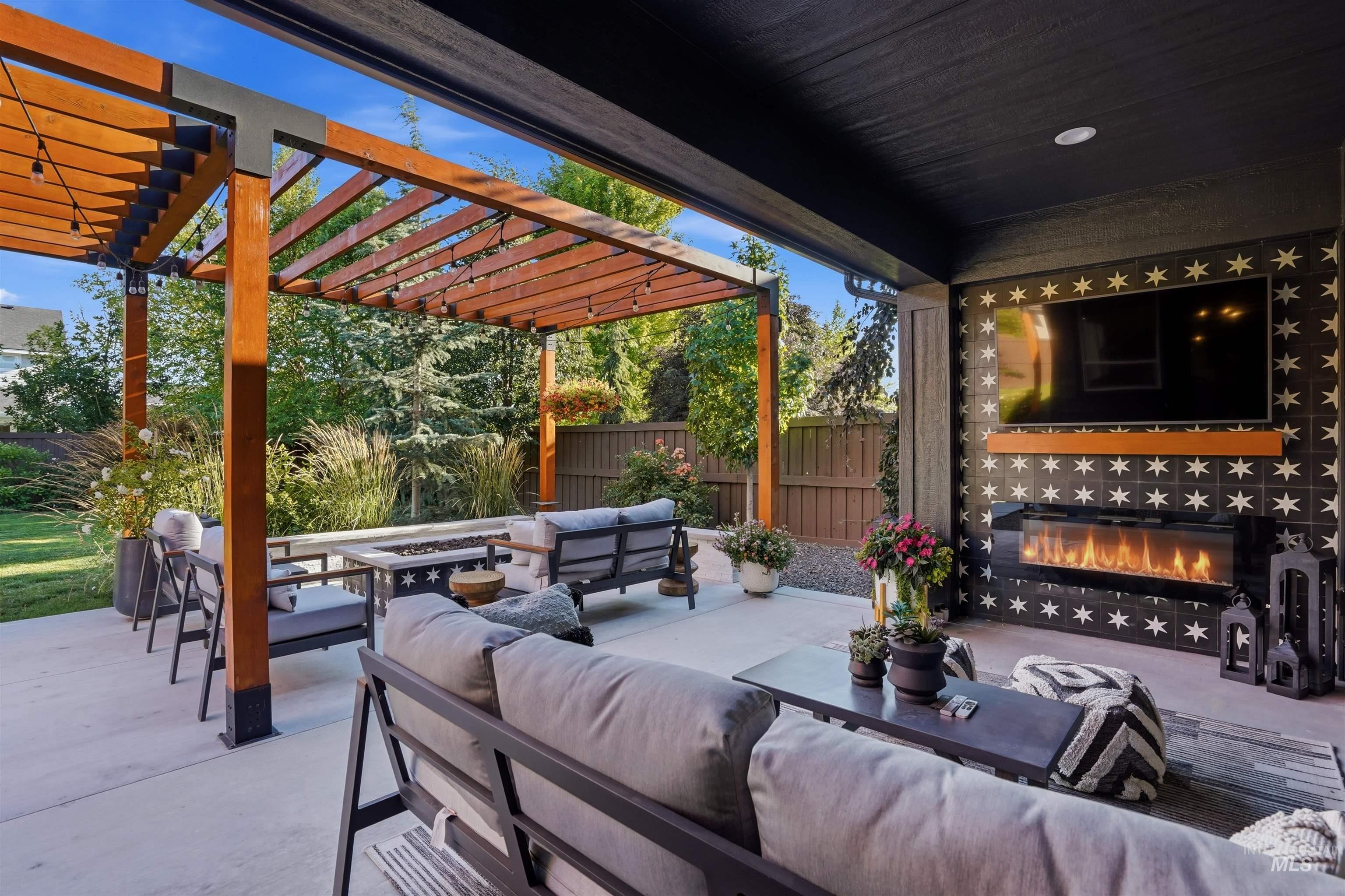 Covered patio featuring an outdoor fireplace with decorative tile surround and an integrated television