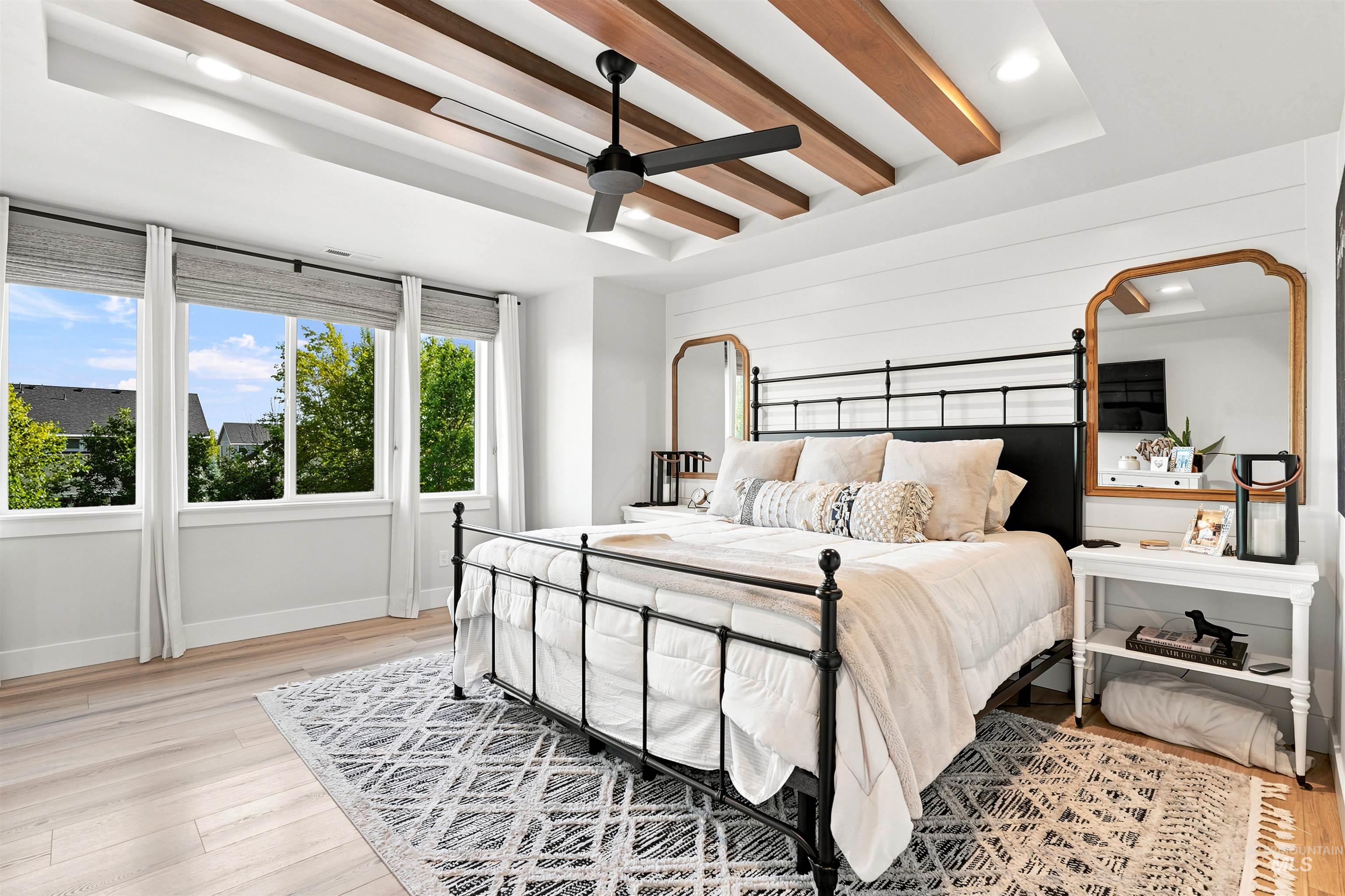 Recessed ceiling with exposed wood beams and a ceiling fan