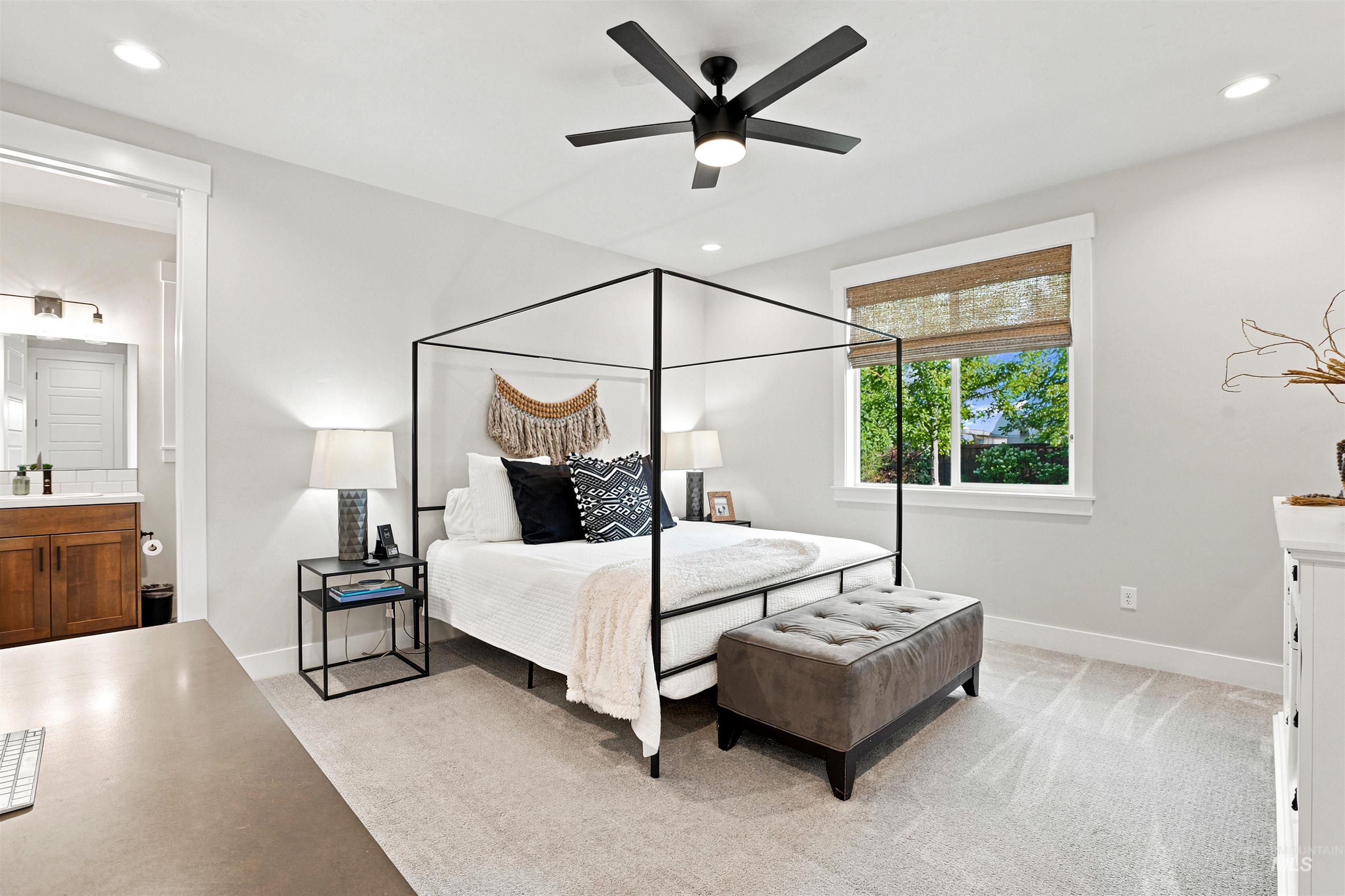 Light-filled room featuring a broad window, recessed lighting, and a dark-toned ceiling fan