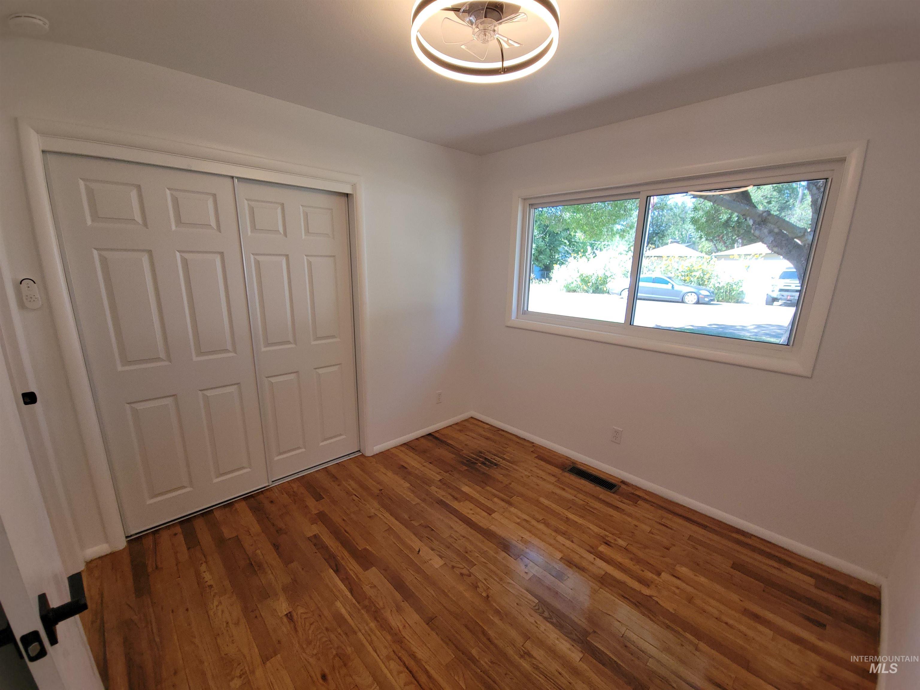 Unfurnished bedroom featuring a closet and wood finished floors