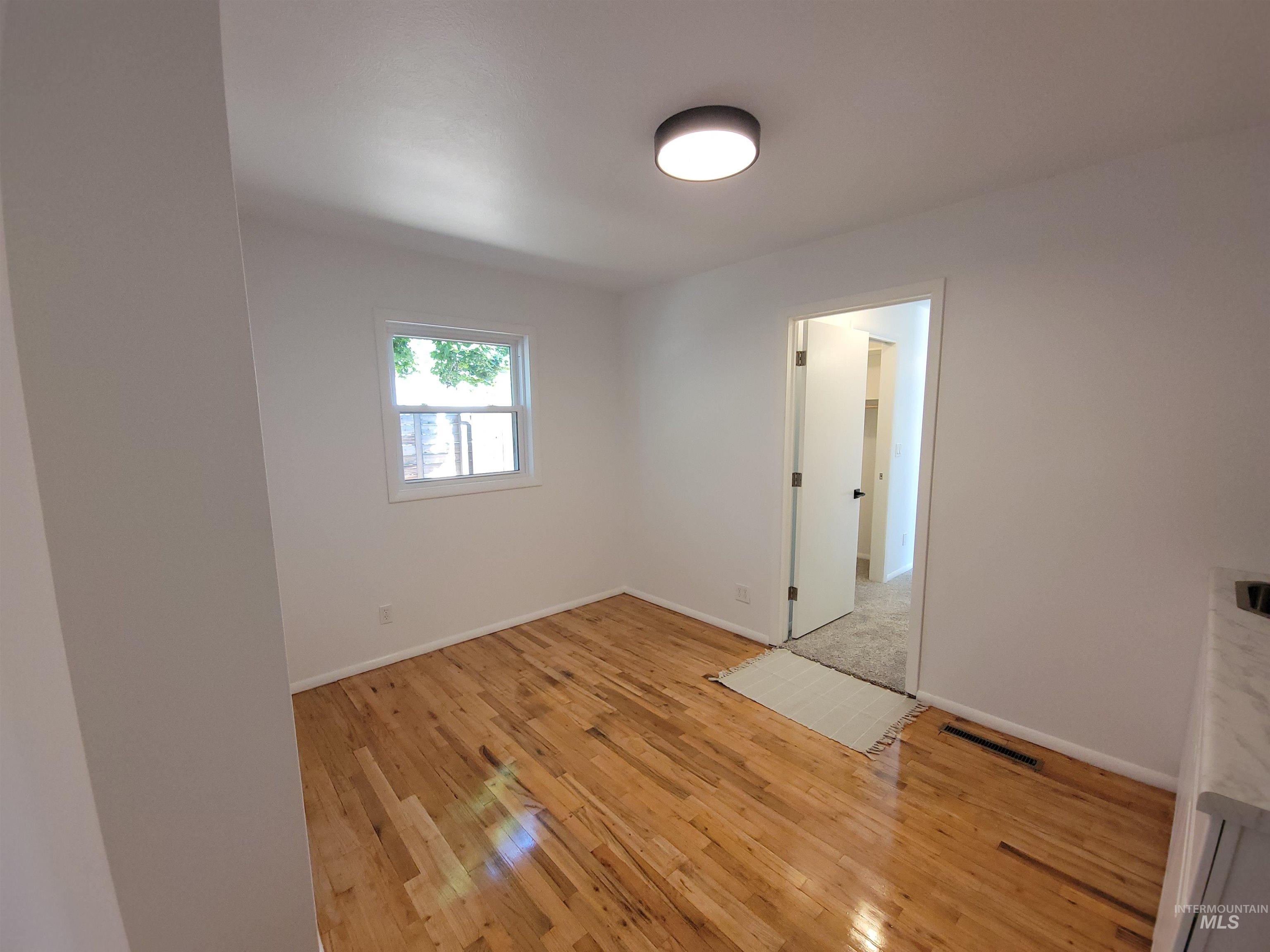 Unfurnished room featuring light wood-style flooring and baseboards