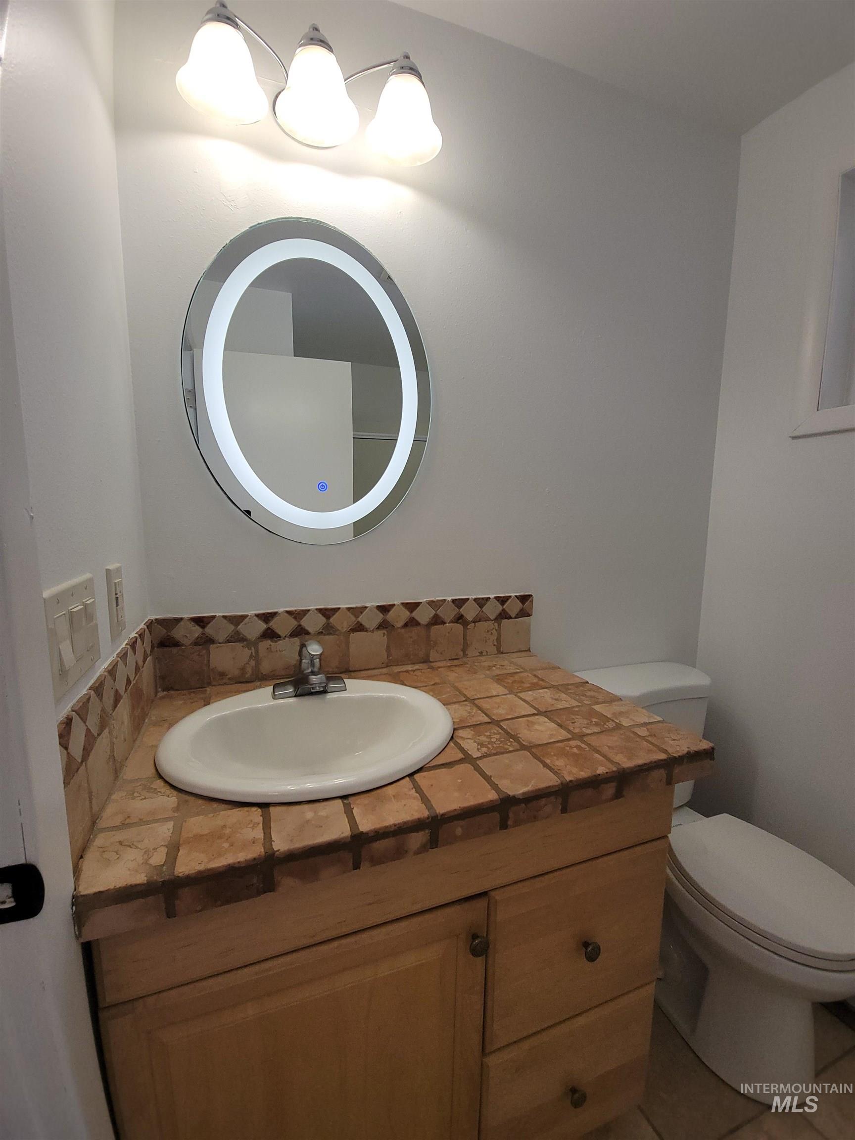 Half bathroom featuring vanity and tasteful backsplash