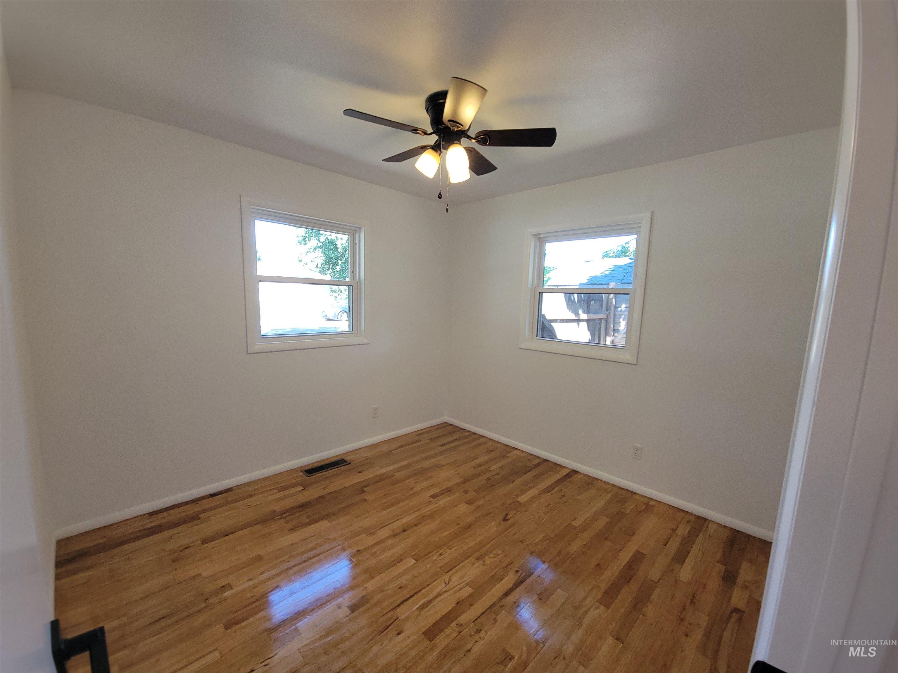 Empty room featuring light wood finished floors and baseboards