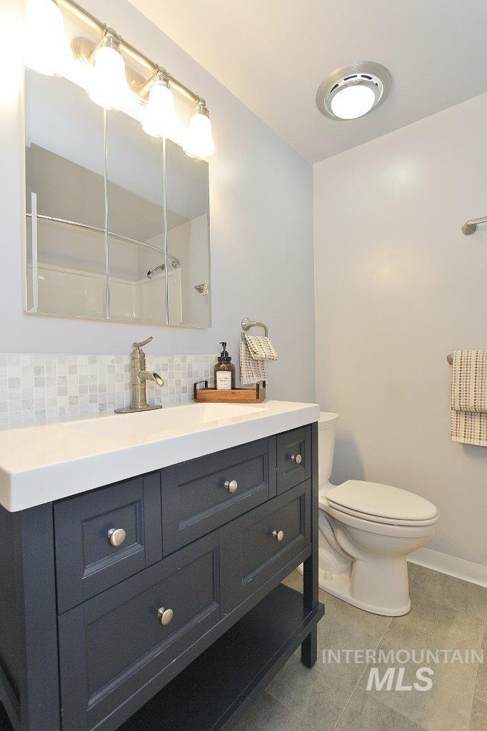 Bathroom featuring vanity, backsplash, and tile patterned flooring