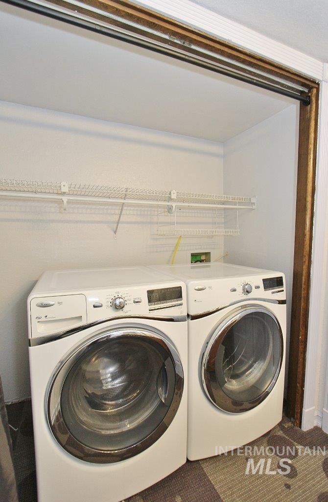 Laundry area featuring washer and clothes dryer and carpet