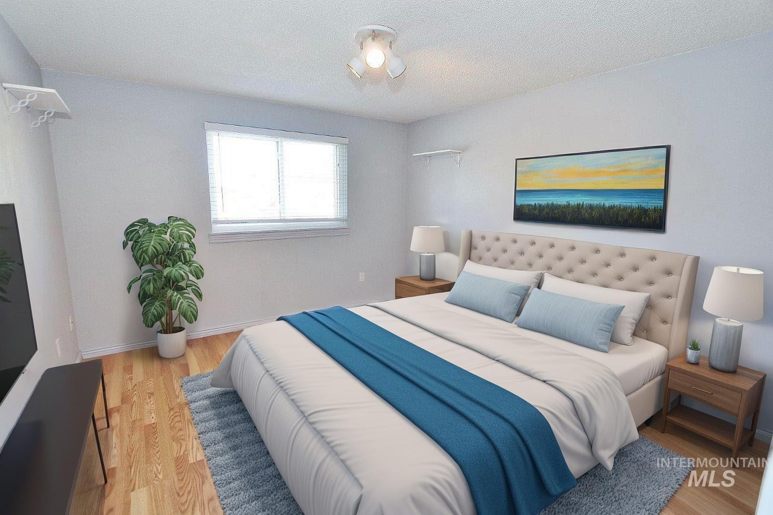 Bedroom with light wood-style flooring and a textured ceiling