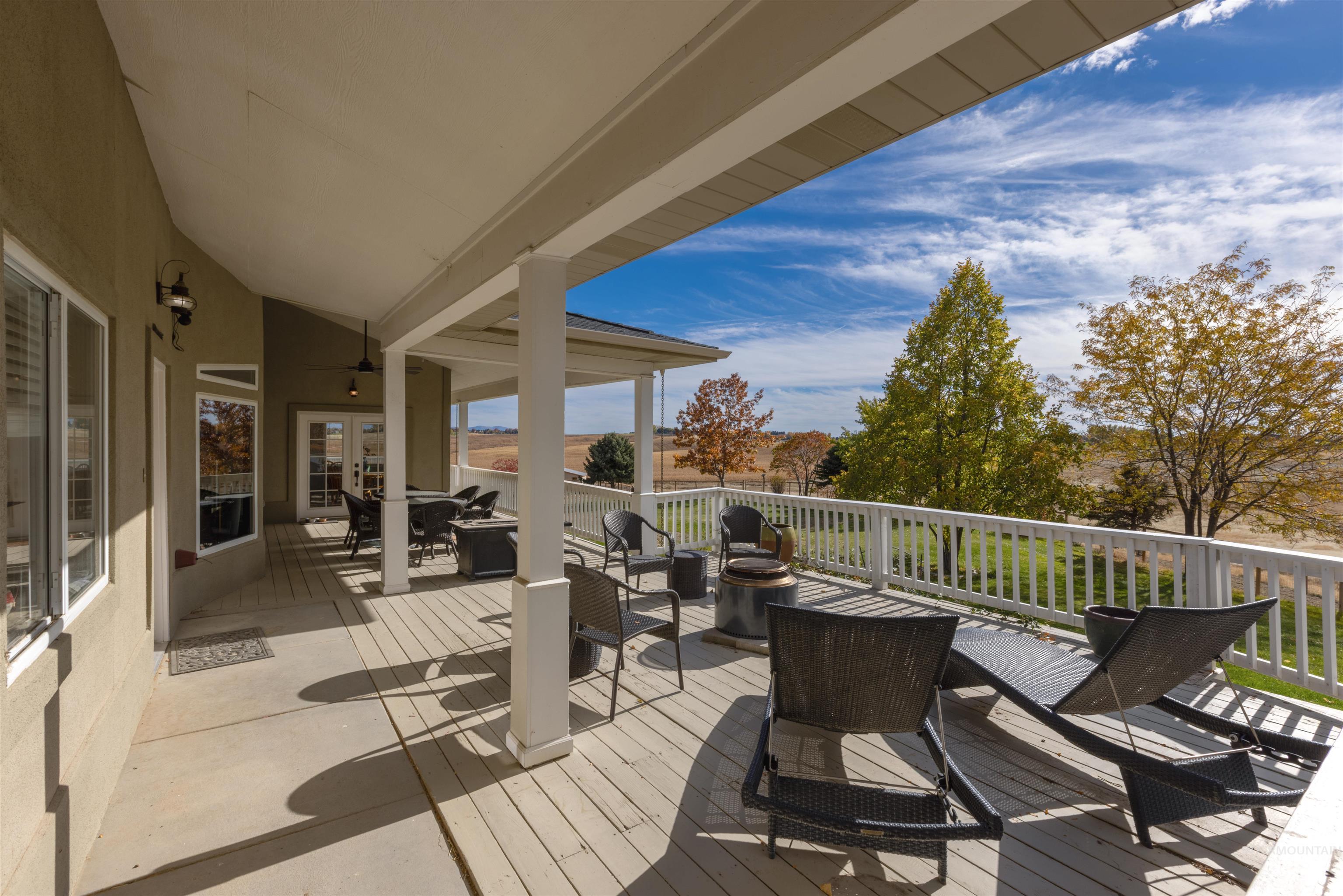 Wooden deck featuring outdoor dining area, ceiling fan, and french doors