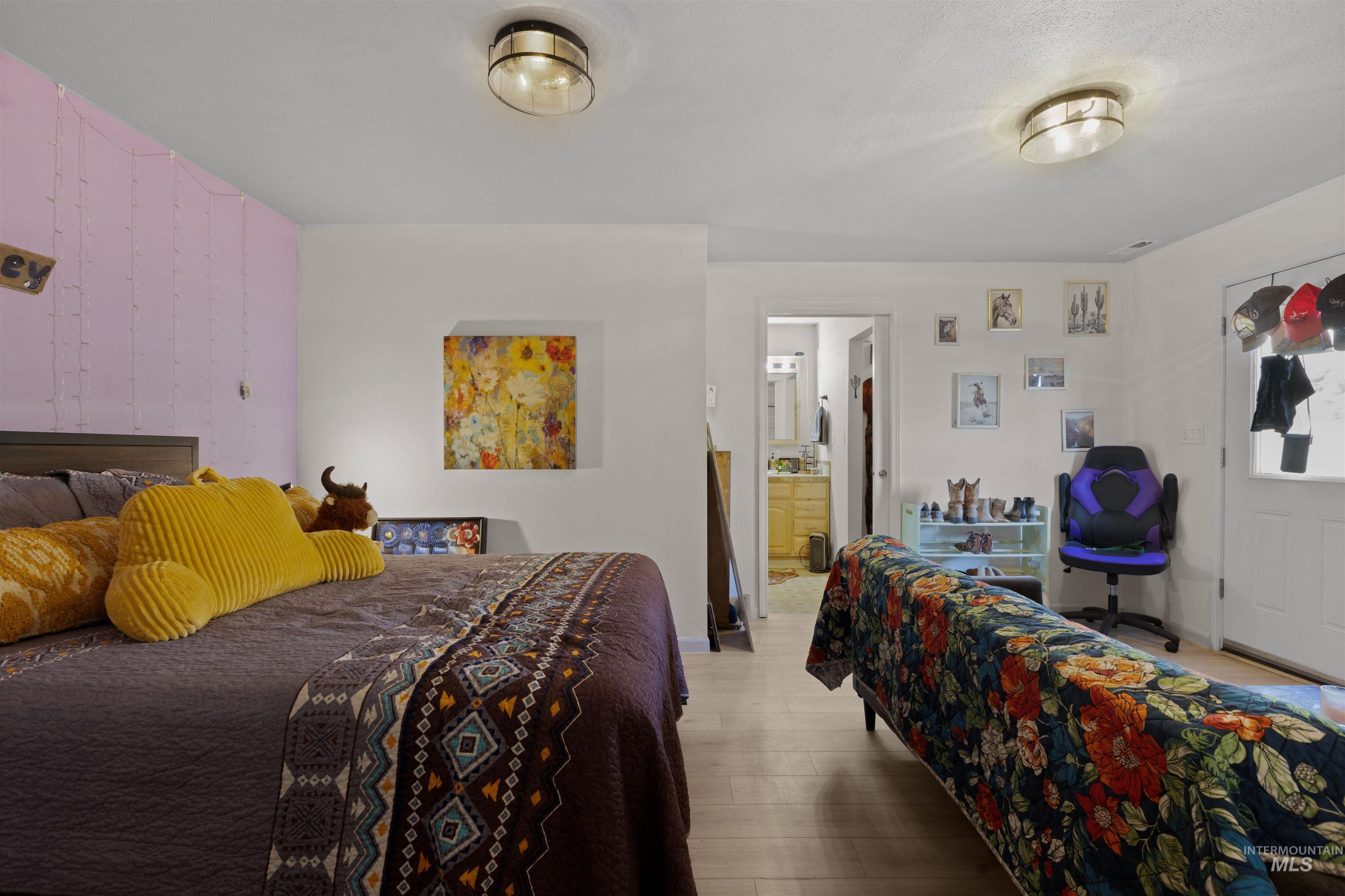 Bedroom featuring wood finished floors and ensuite bath