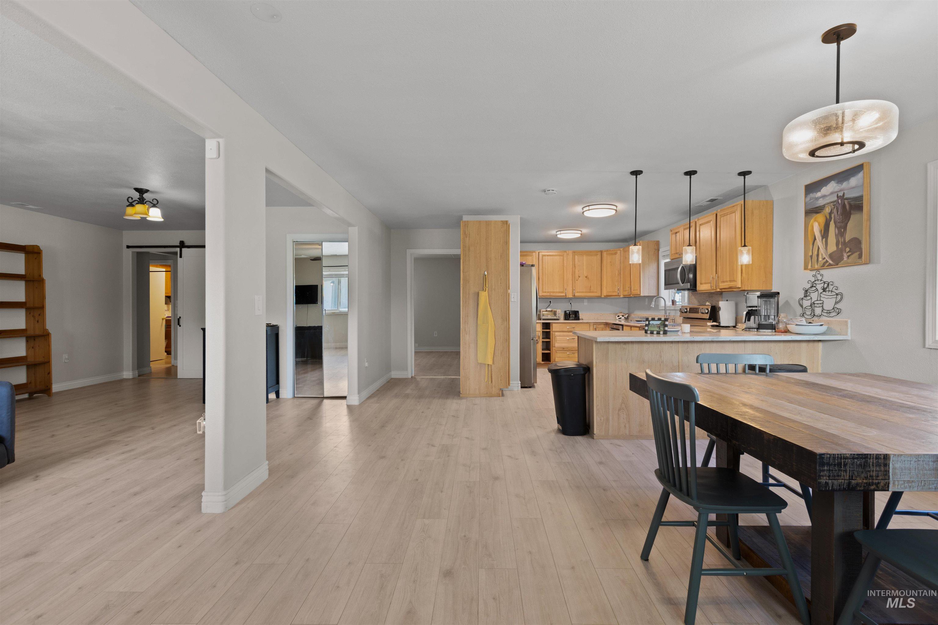 Dining space featuring a barn door and light wood finished floors