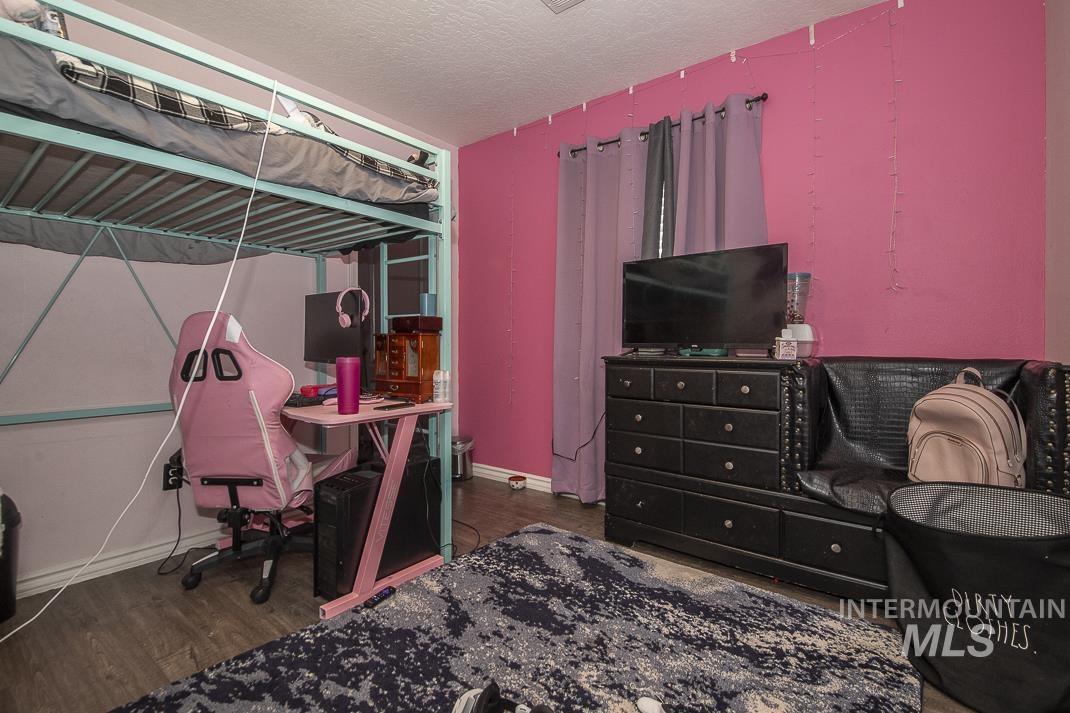 Bedroom featuring a textured ceiling and dark wood-style floors