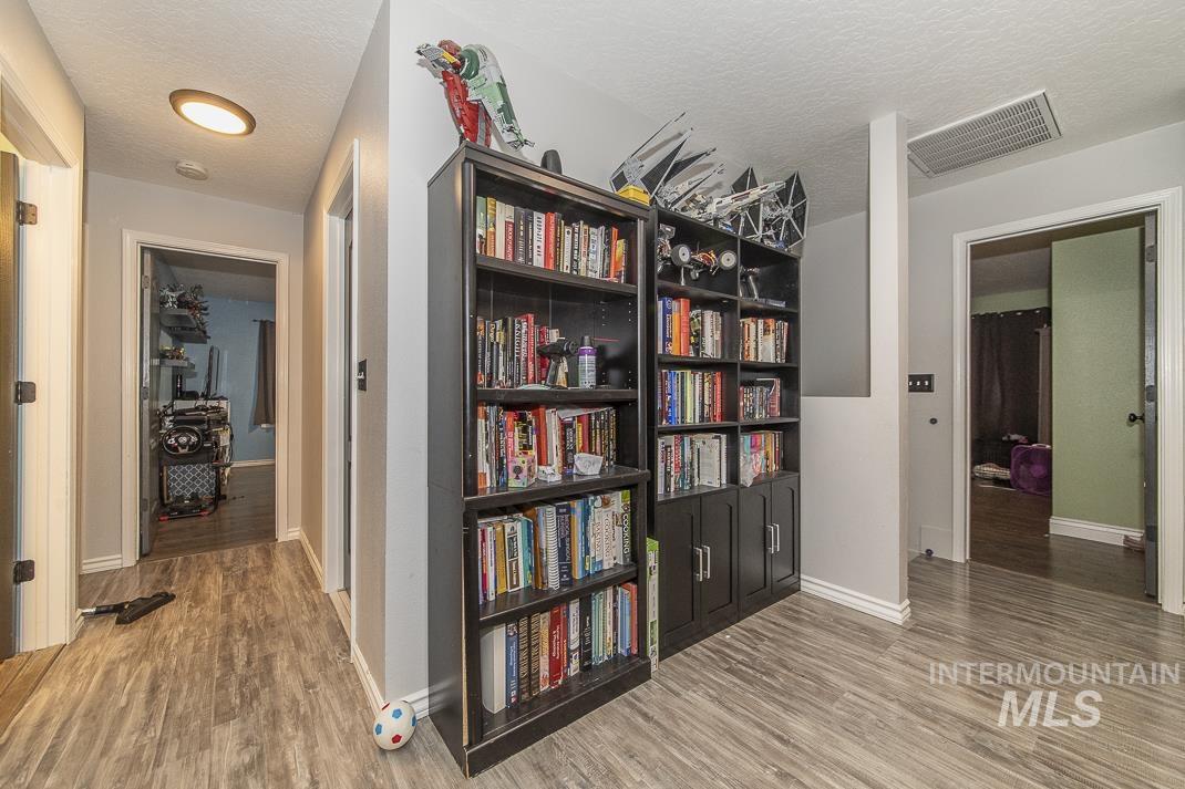 Corridor with light wood-style floors and a textured ceiling