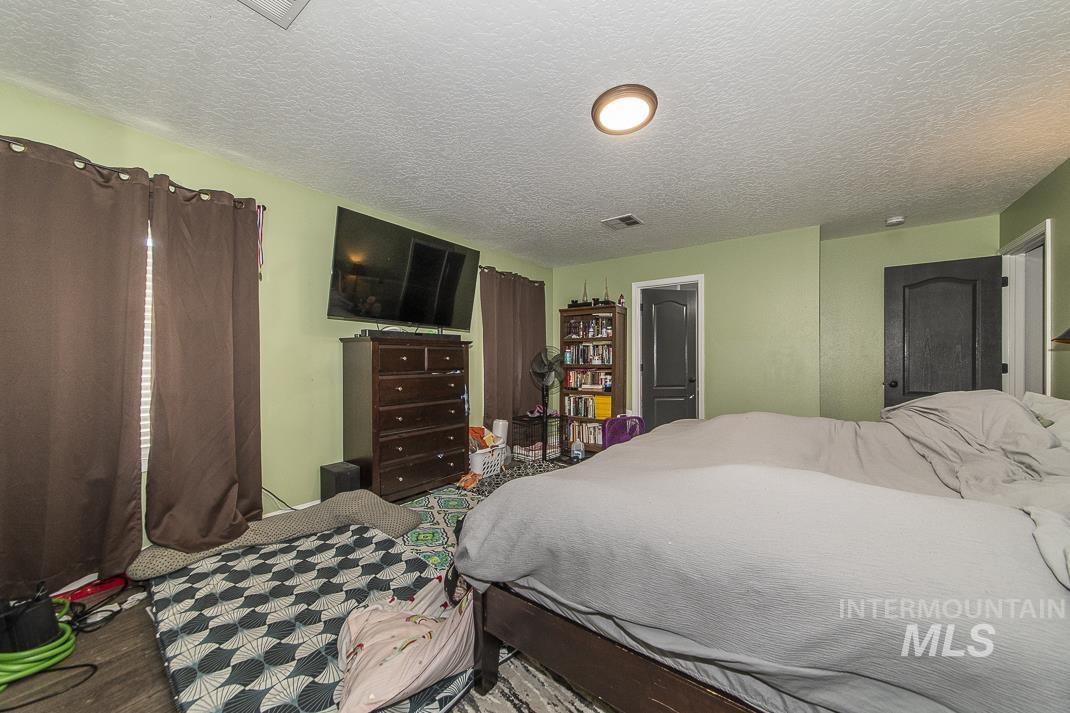 Bedroom featuring a textured ceiling and wood finished floors