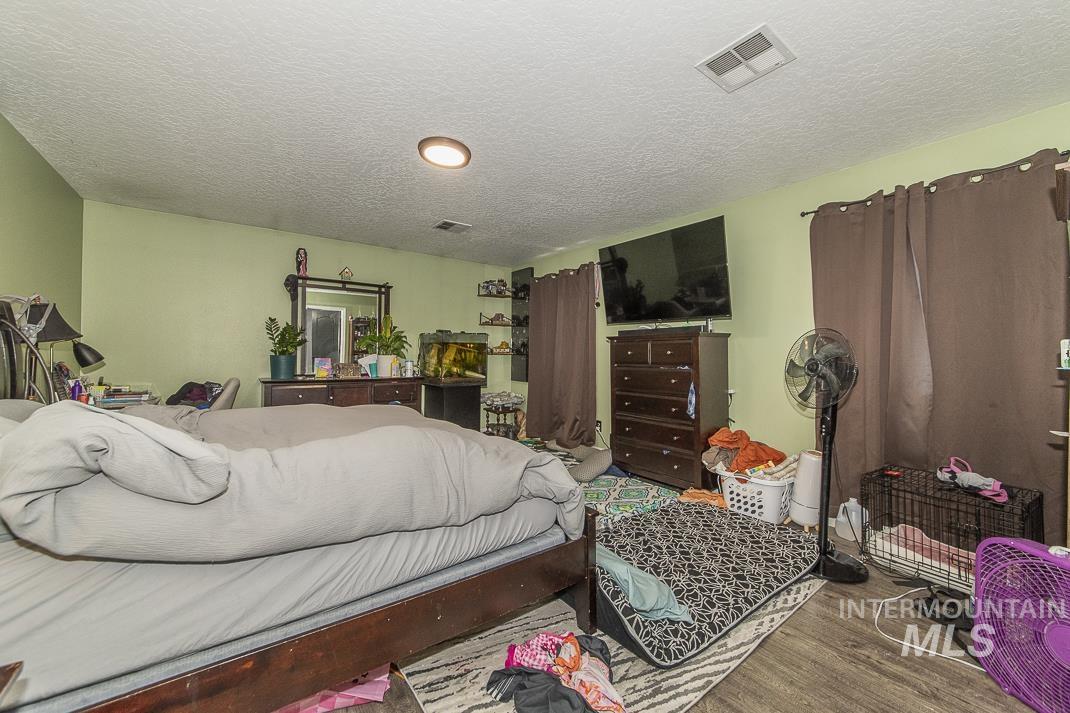 Bedroom featuring a textured ceiling and wood finished floors