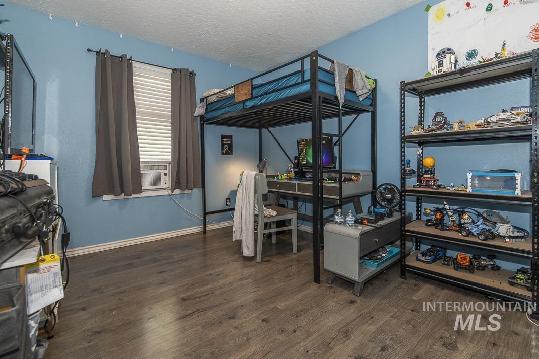 Bedroom featuring dark wood-type flooring and a textured ceiling