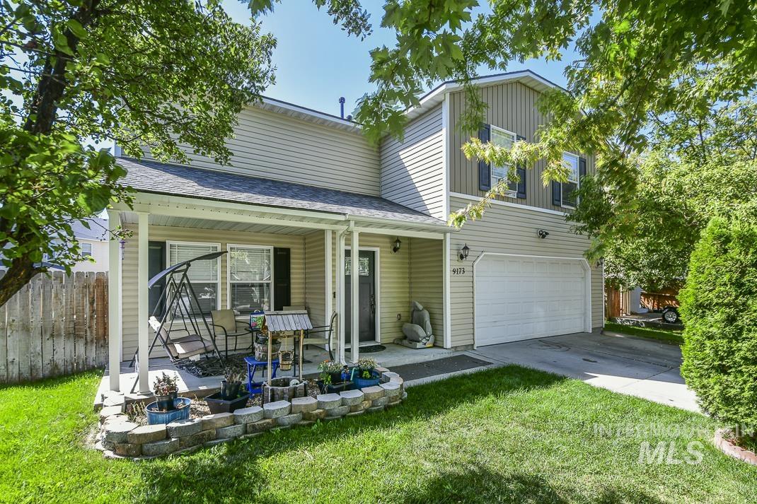 Traditional-style home with an attached garage, driveway, and a shingled roof