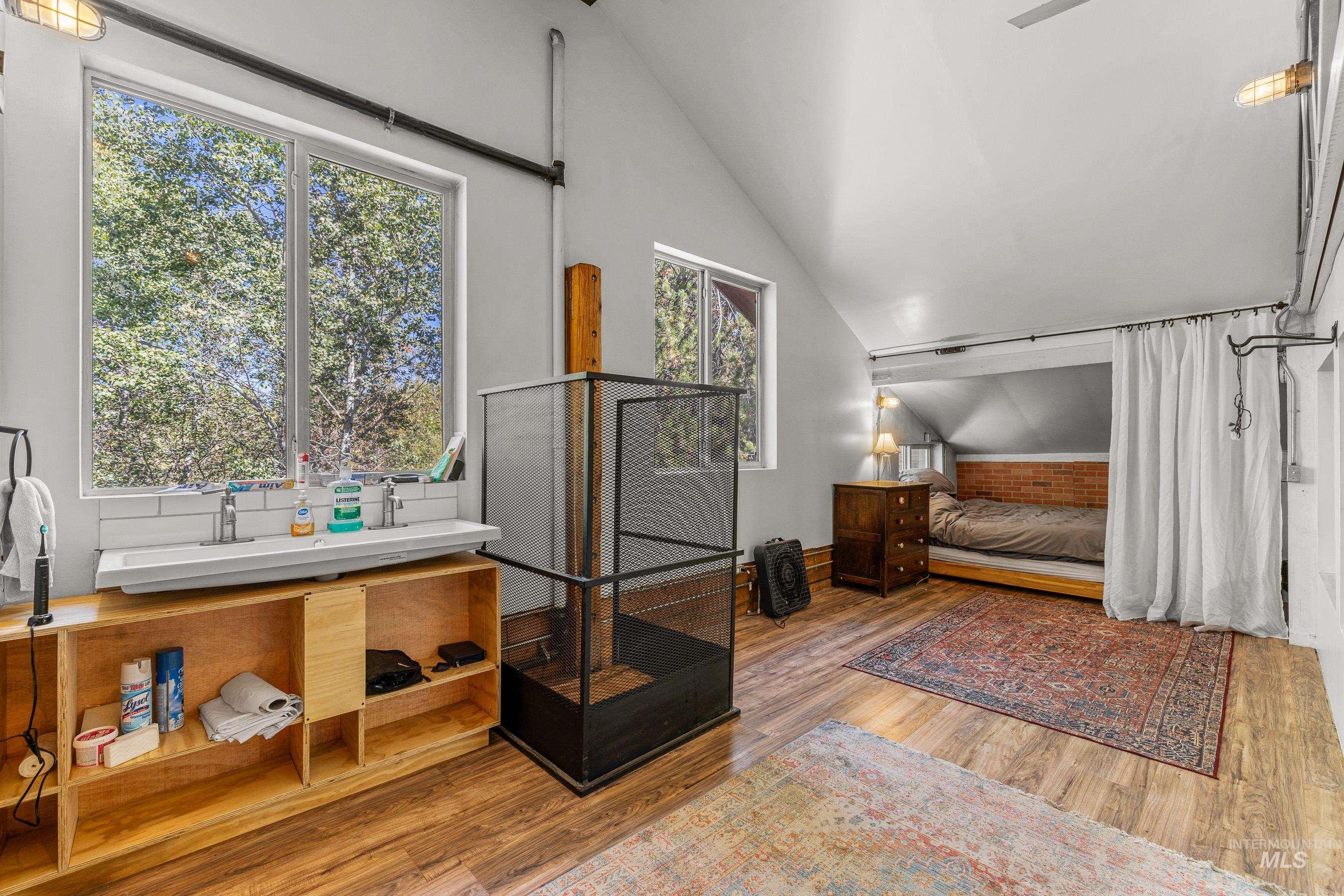 Bedroom featuring vaulted ceiling, wood finished floors, and ceiling fan