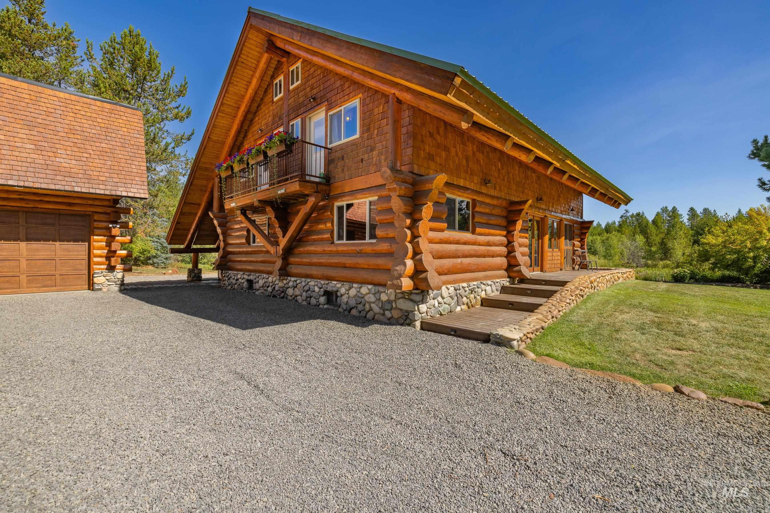 View of home's exterior with log exterior and driveway