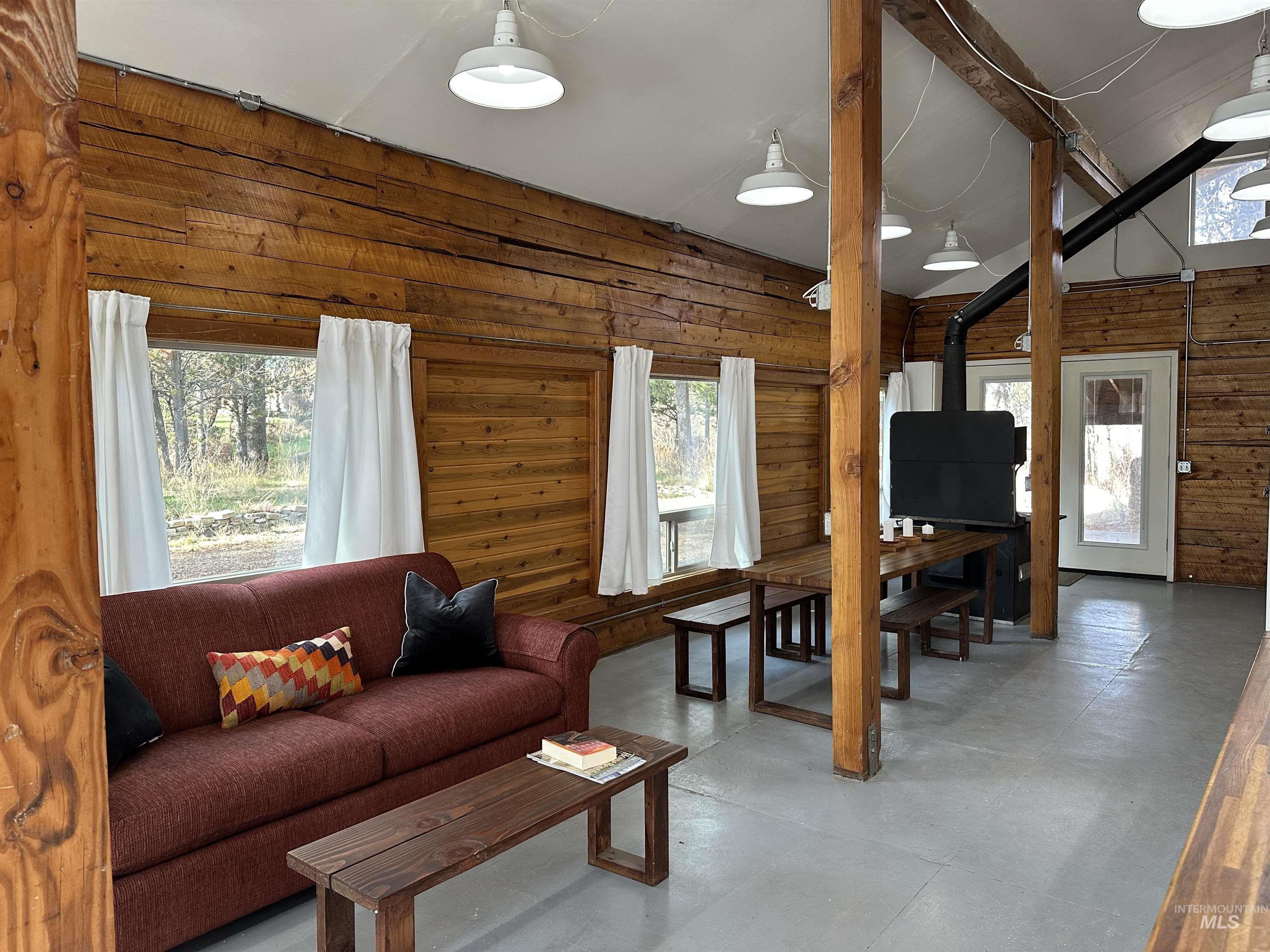 Living area featuring wooden walls and a wood stove