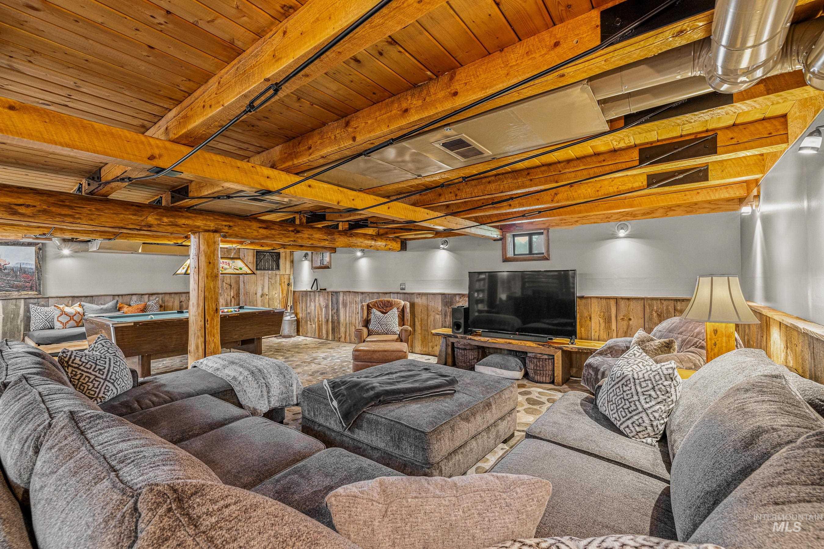 Living area featuring pool table, wainscoting, and wood walls
