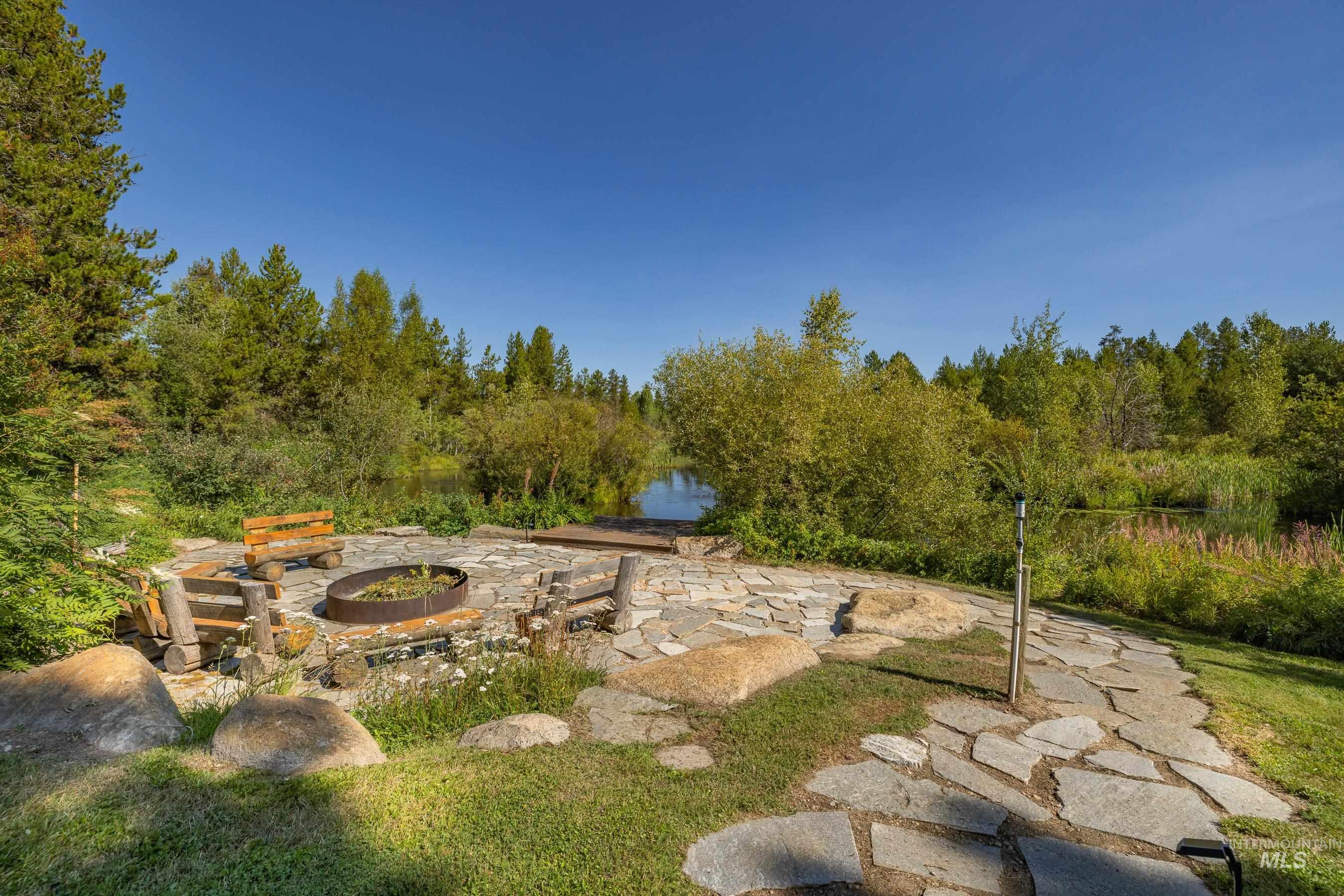 View of yard featuring an outdoor fire pit, a patio, and a water view