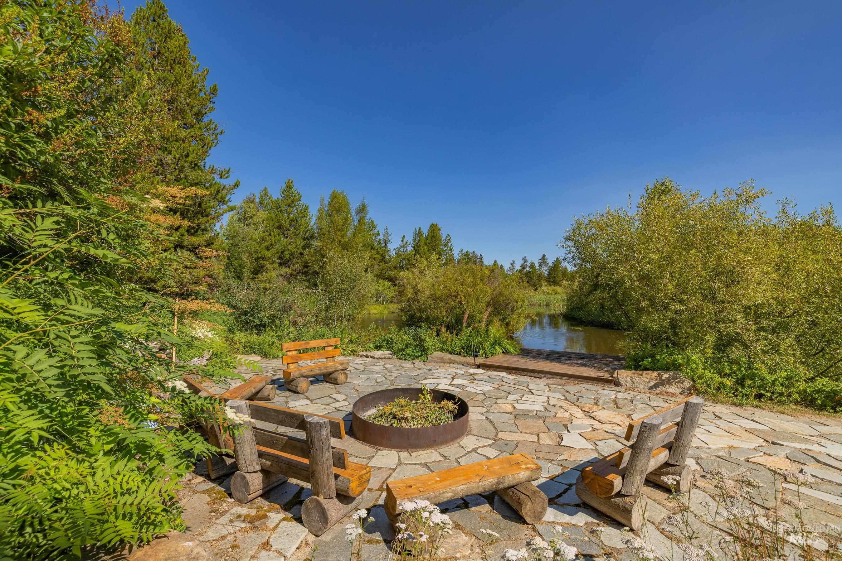 View of patio with an outdoor fire pit and a water view