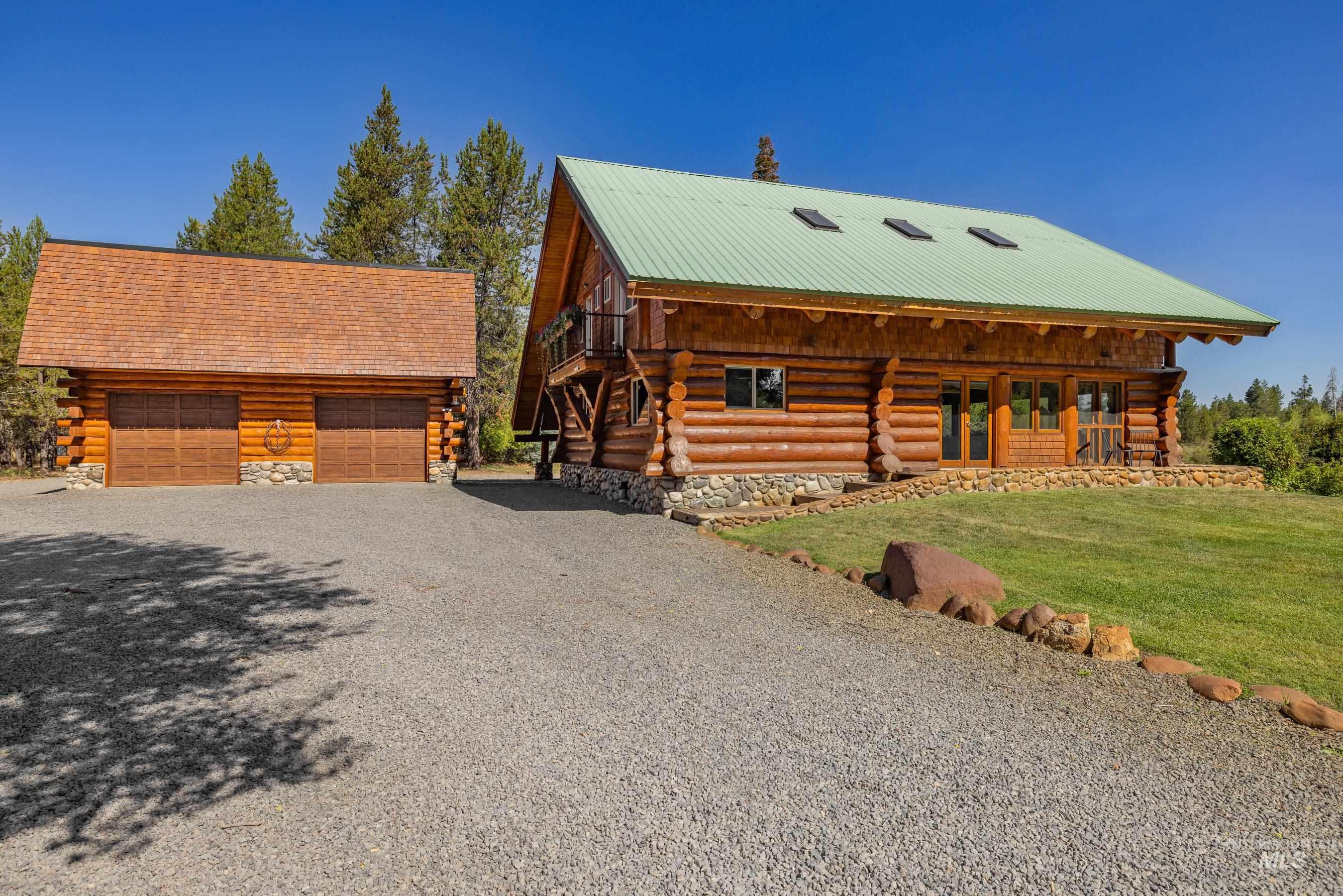 Log-style house featuring log exterior, an outdoor structure, and a front lawn