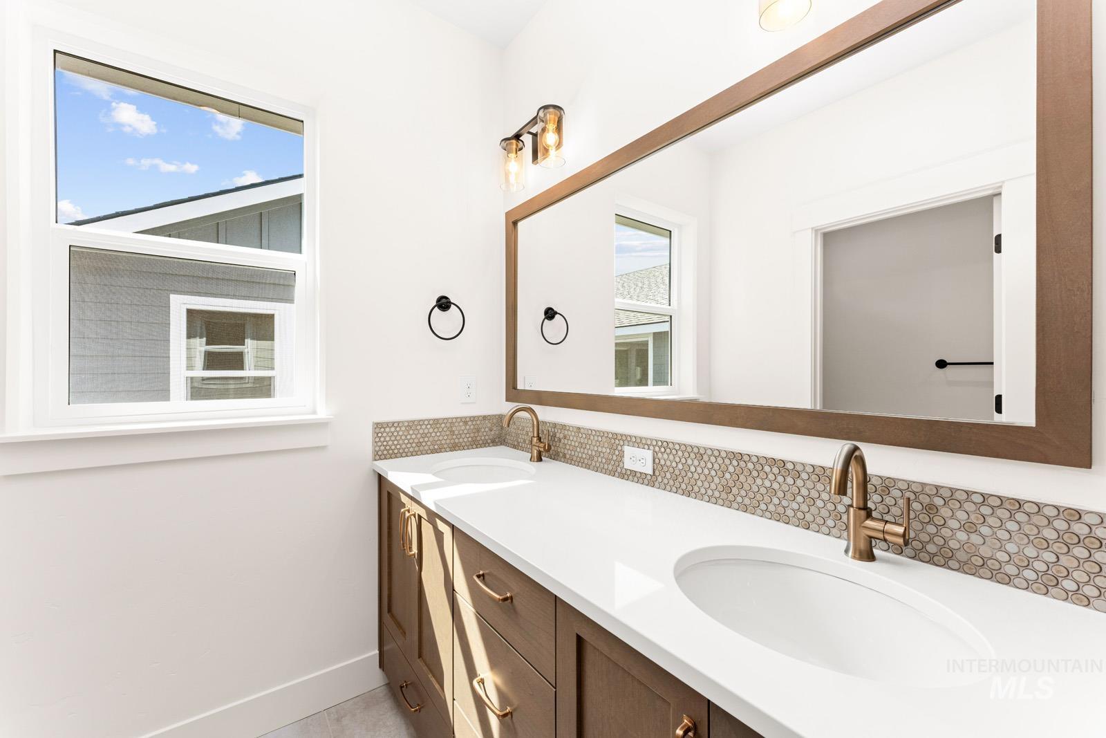 Bathroom with double vanity and baseboards