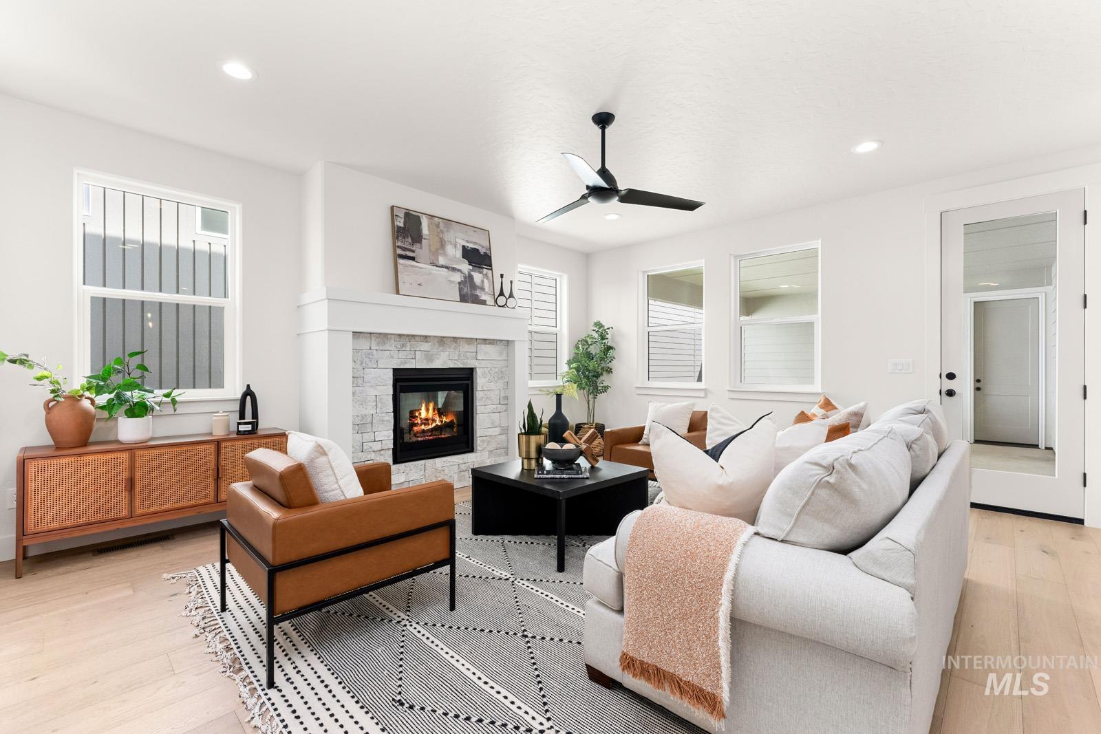 Living area featuring light wood-style flooring, a fireplace, ceiling fan, healthy amount of natural light, and recessed lighting