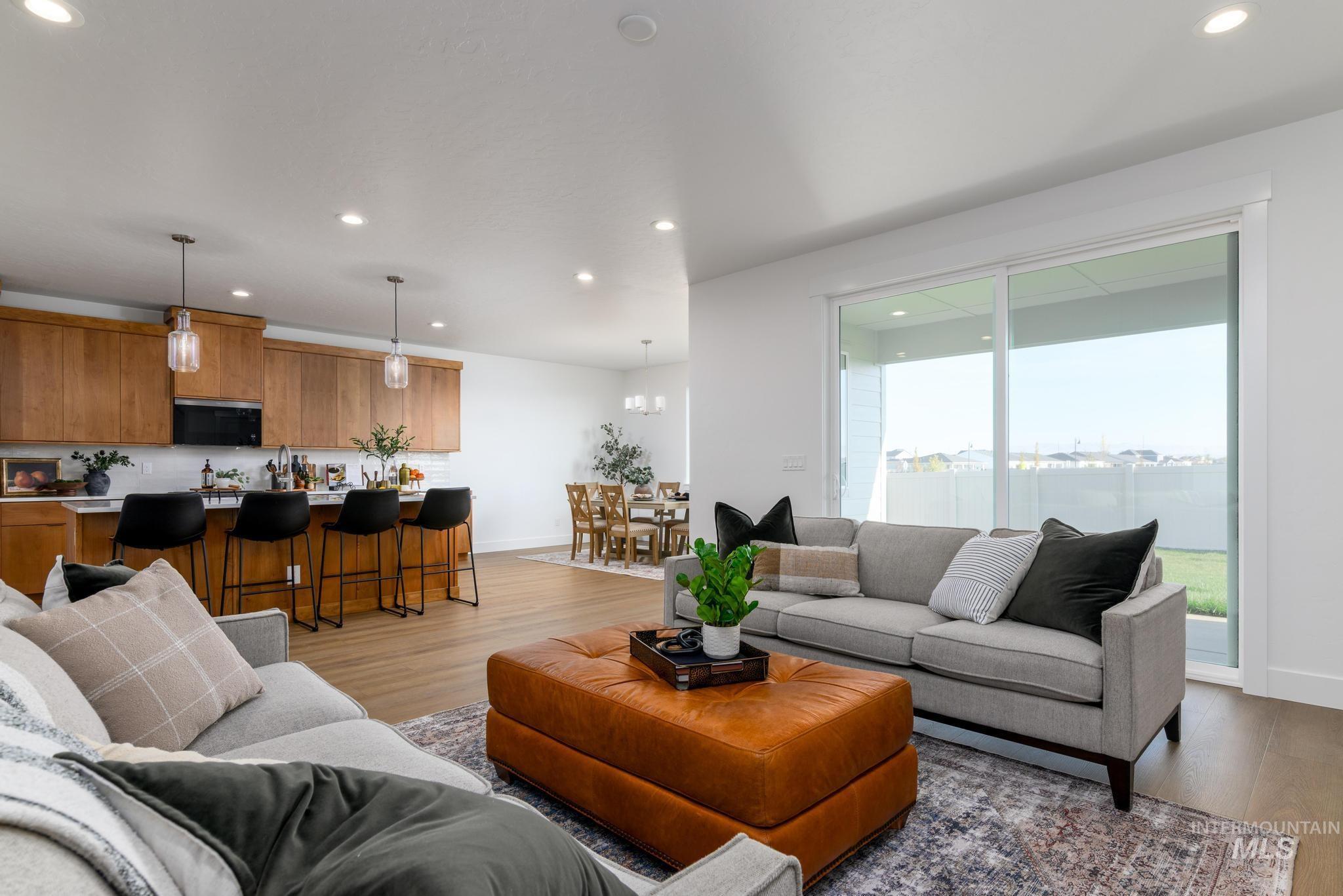 Living room with recessed lighting, light wood-style floors, and a chandelier