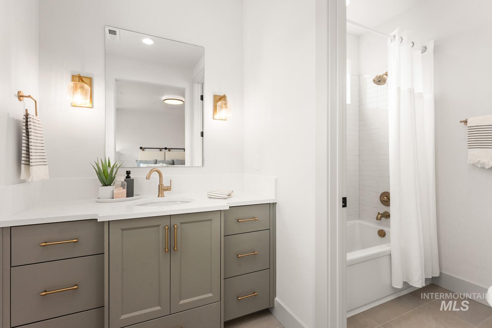 Bathroom with shower / bath combo, vanity, and light tile patterned flooring