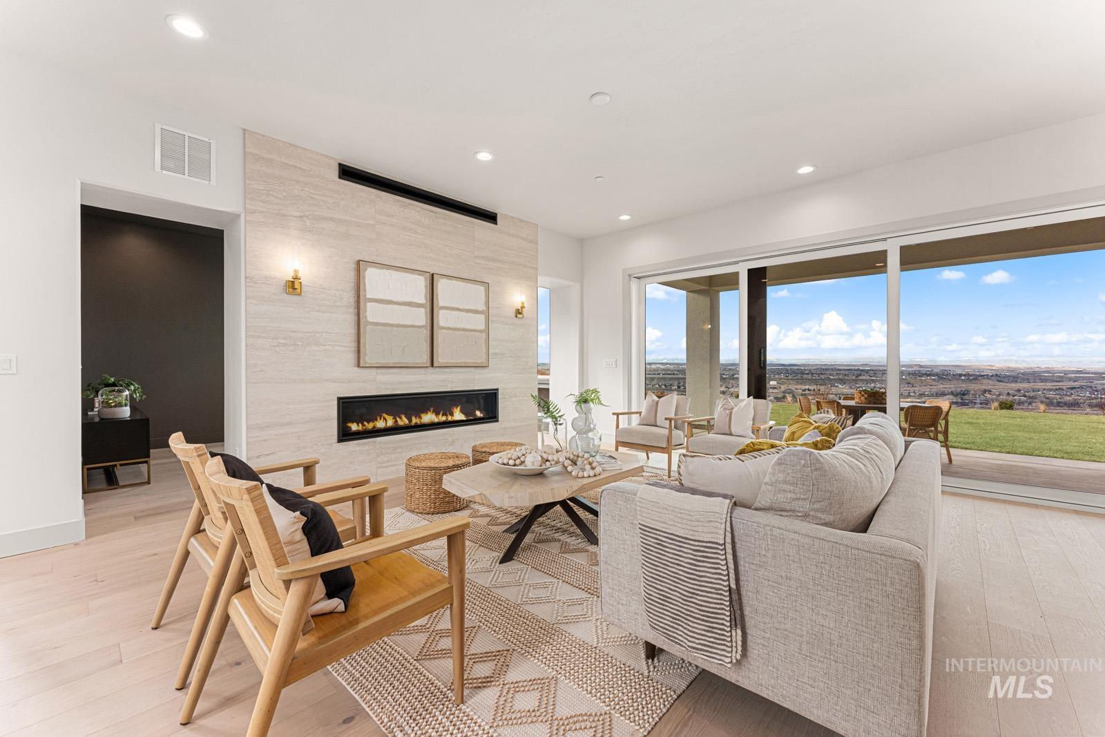 Living room featuring light wood-style floors, a tile fireplace, and recessed lighting