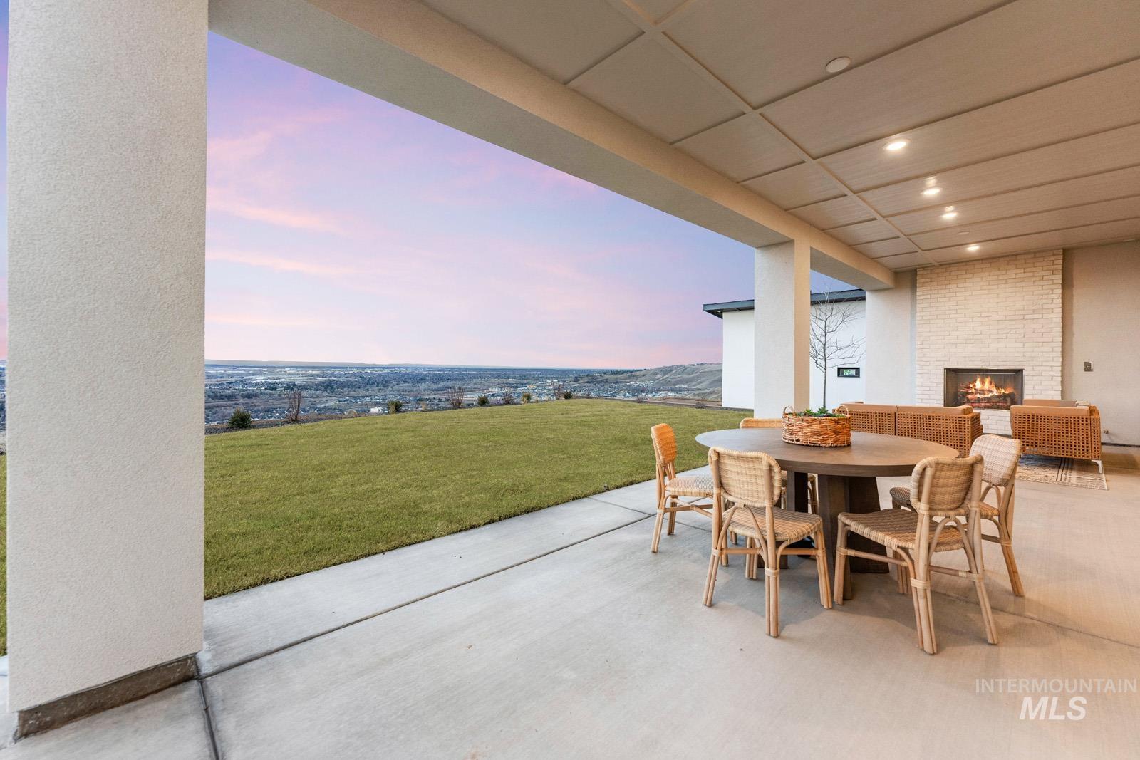 View of patio / terrace featuring an outdoor brick fireplace and outdoor dining area