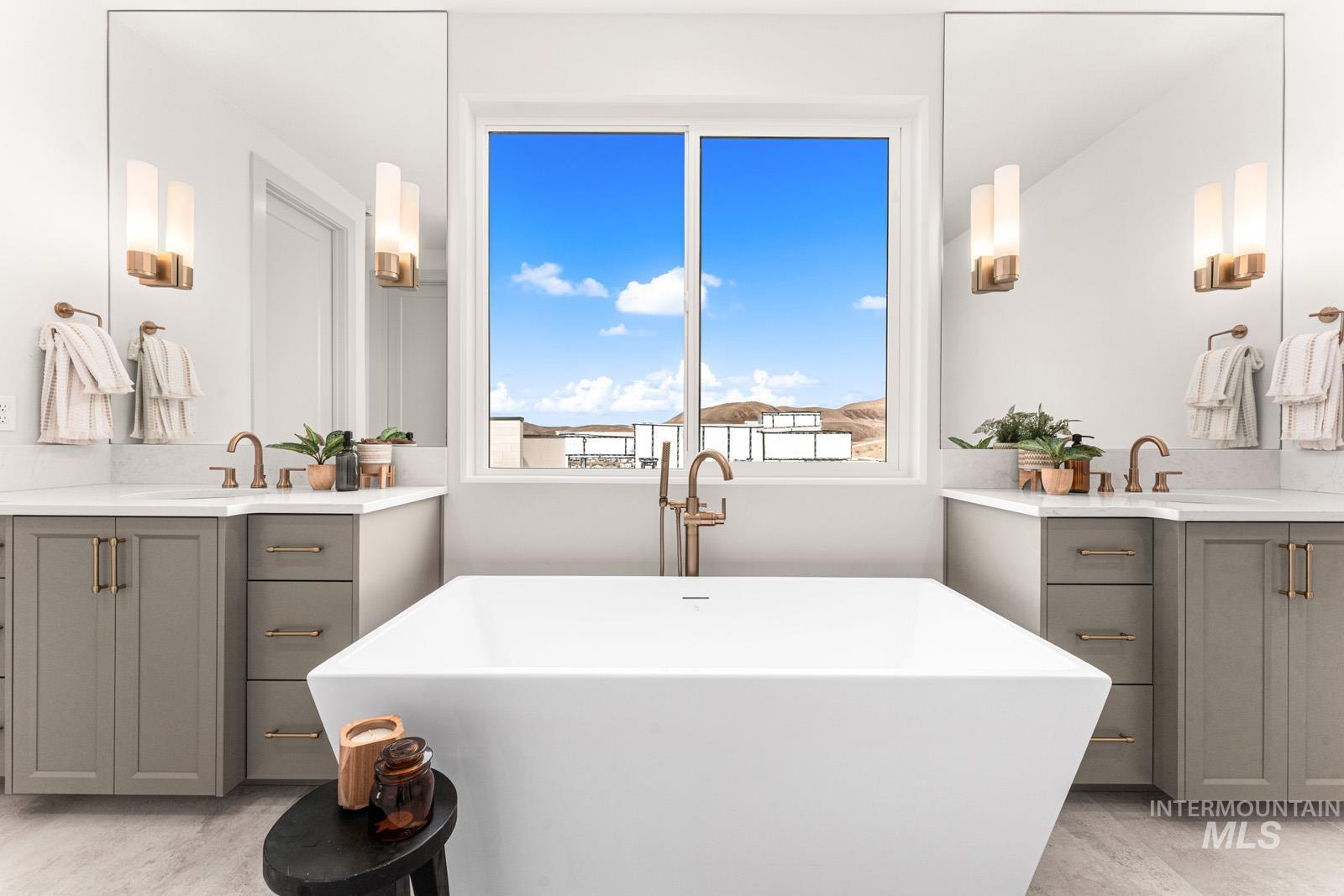Full bath featuring two vanities and a freestanding tub
