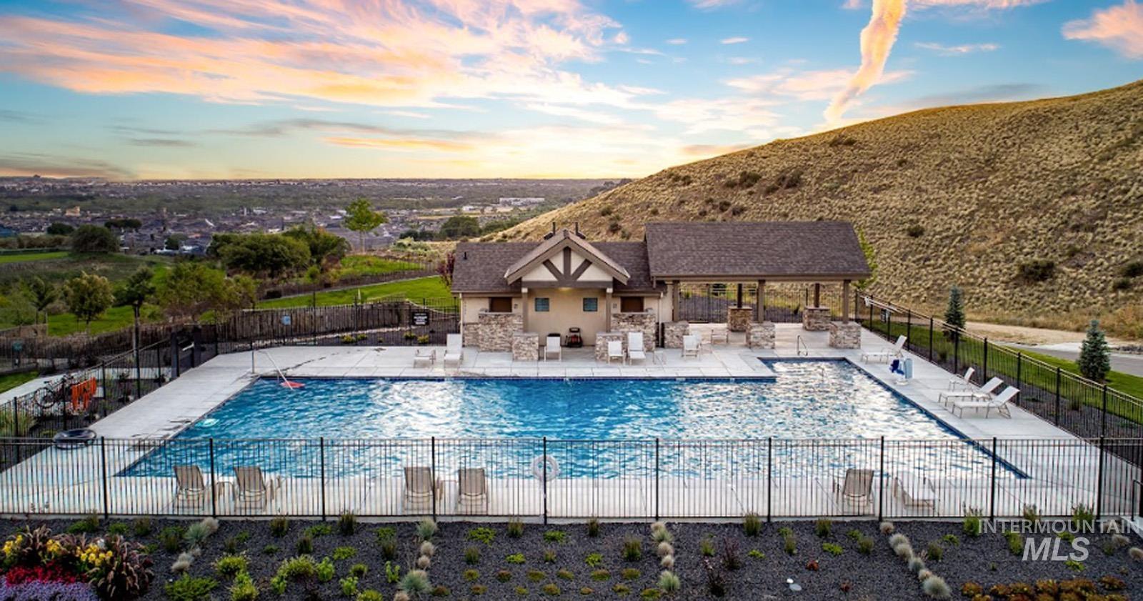 Pool at dusk featuring a patio area and a community pool