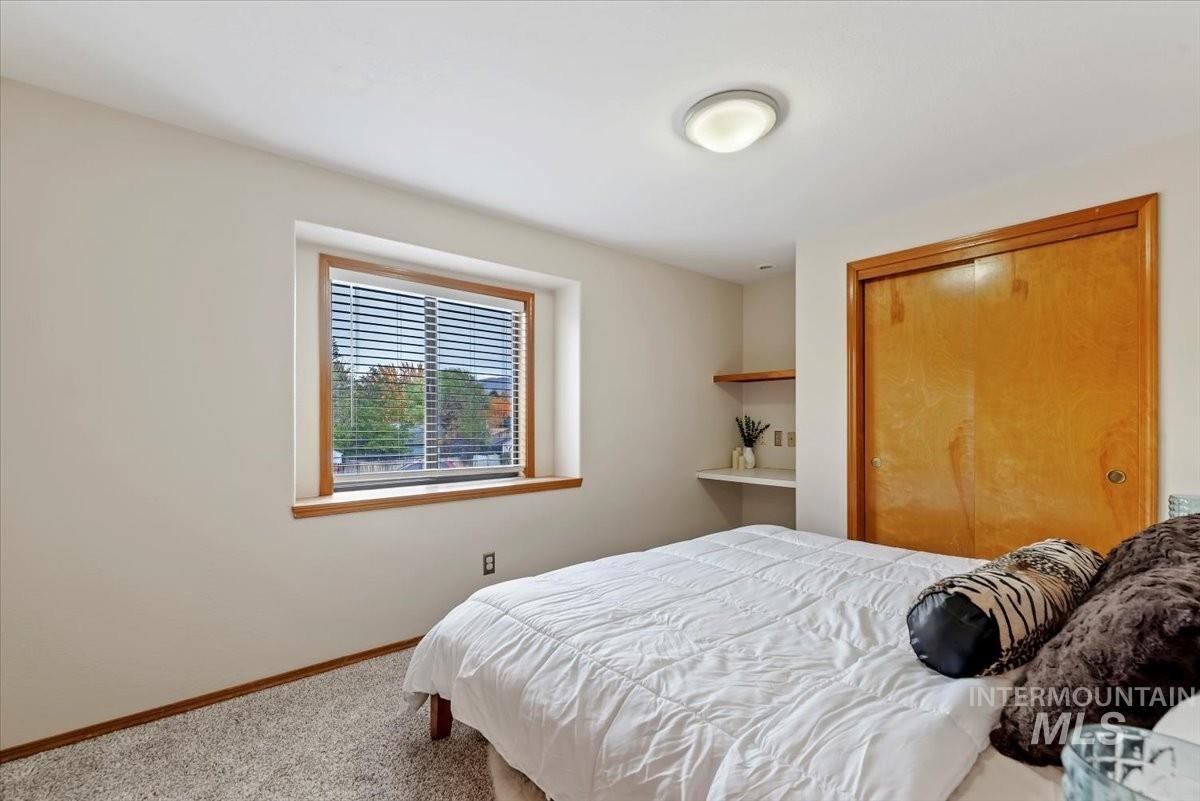 Carpeted bedroom featuring a closet and baseboards