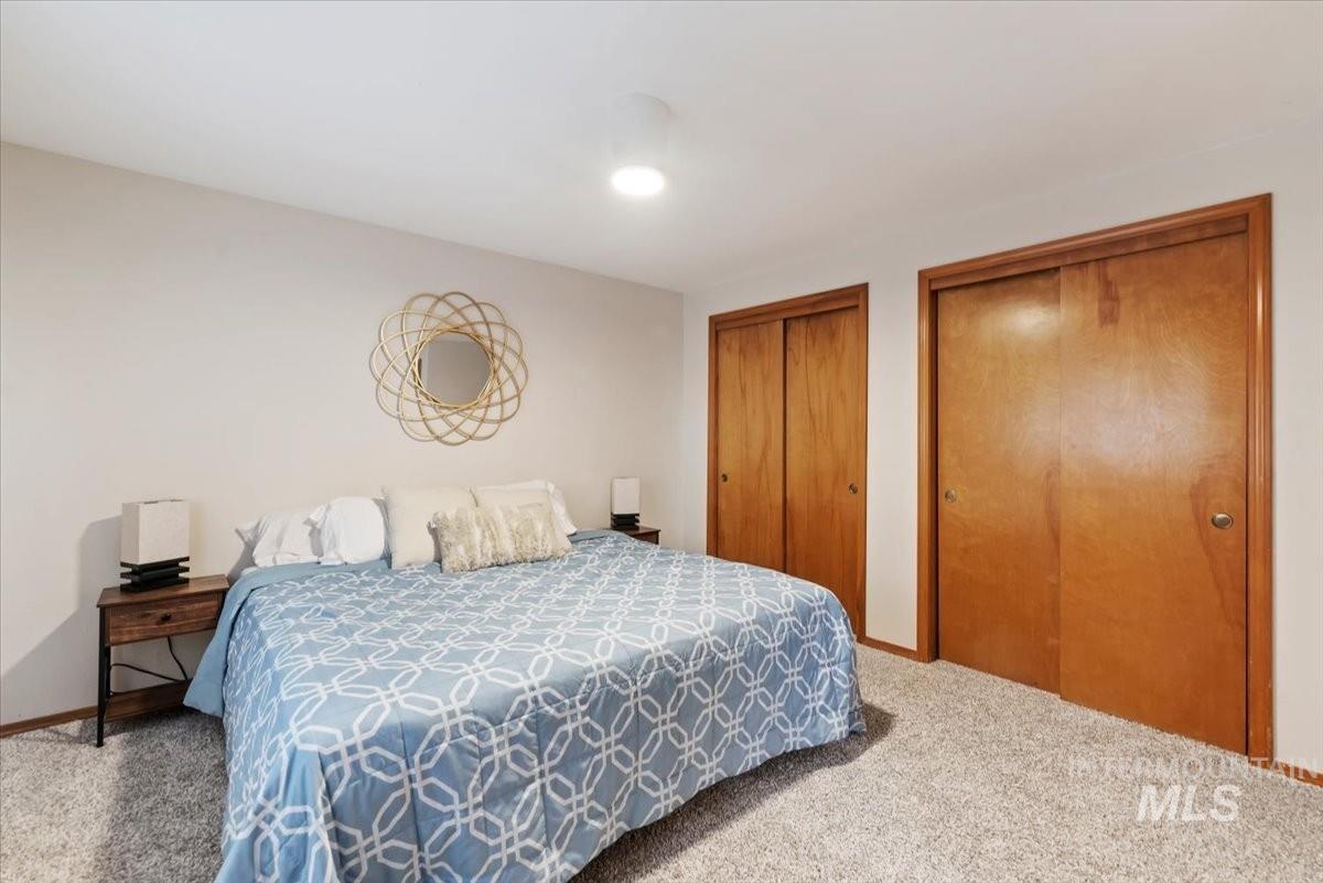 Bedroom featuring multiple closets and carpet