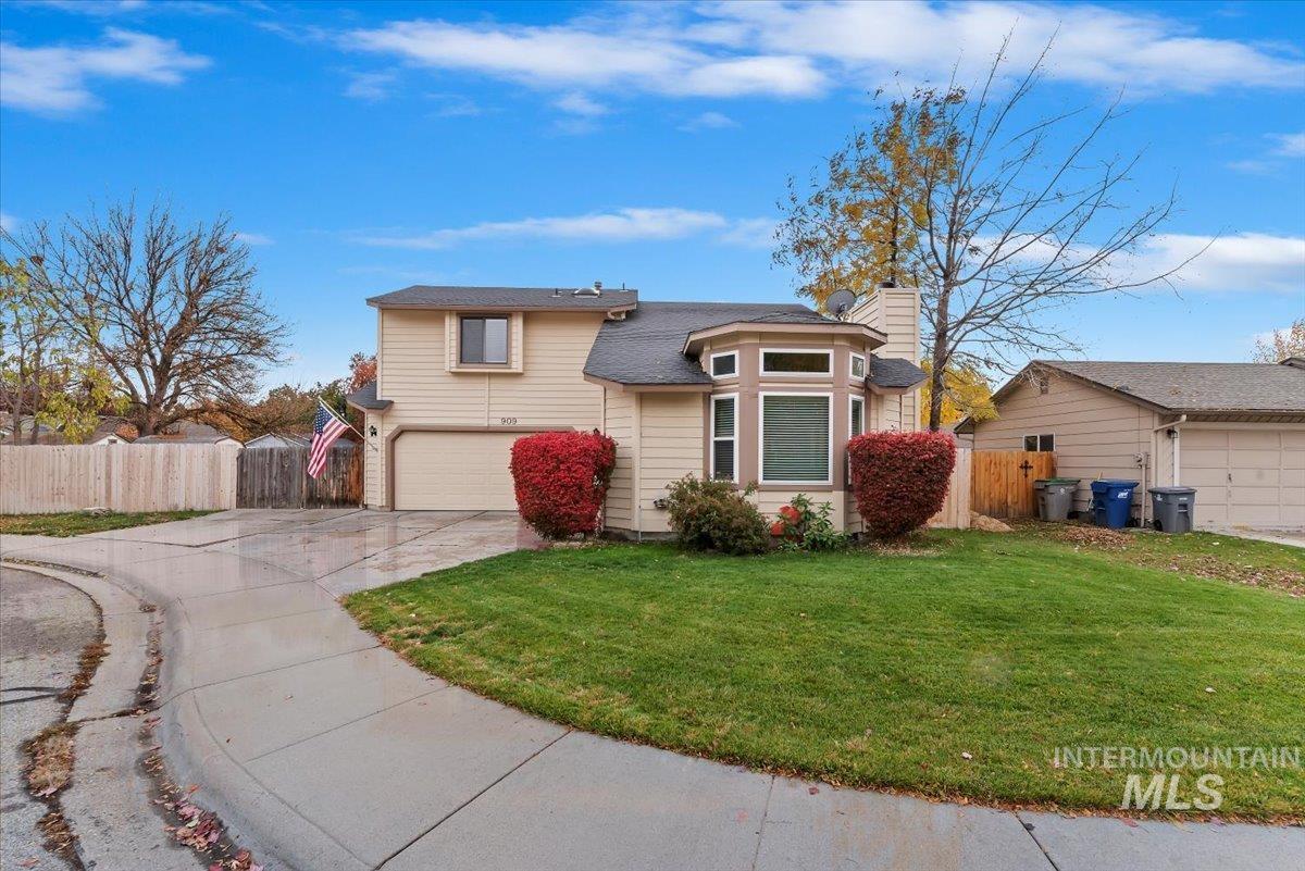 View of front of home featuring driveway, an attached garage, and a chimney