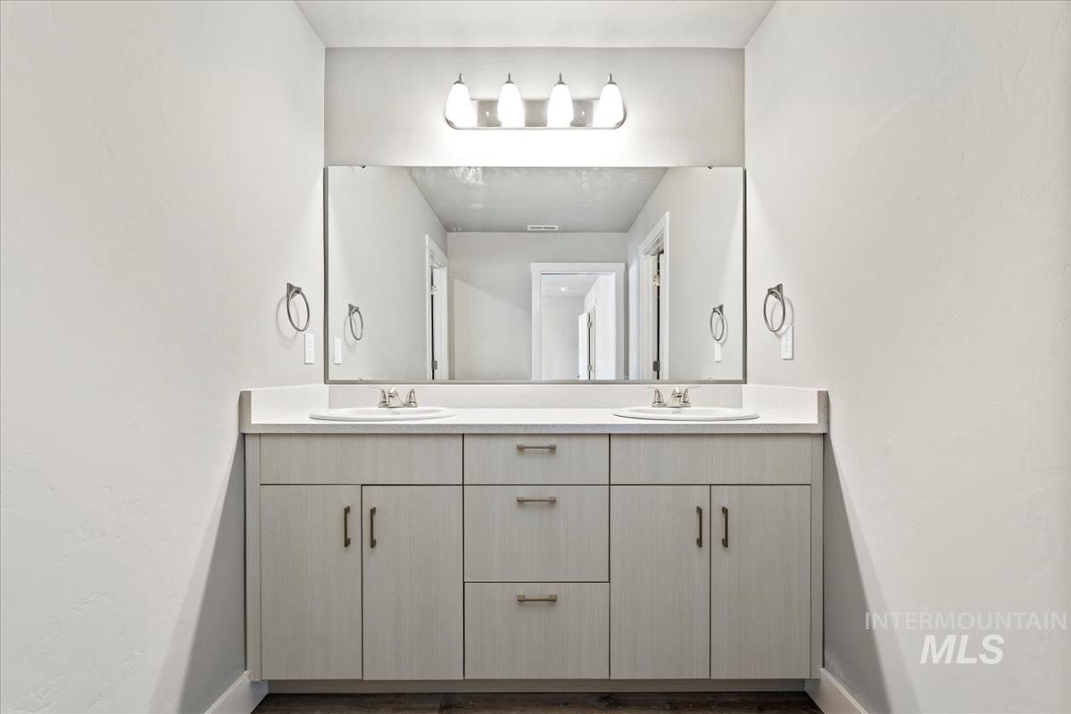 Bathroom with double vanity and baseboards