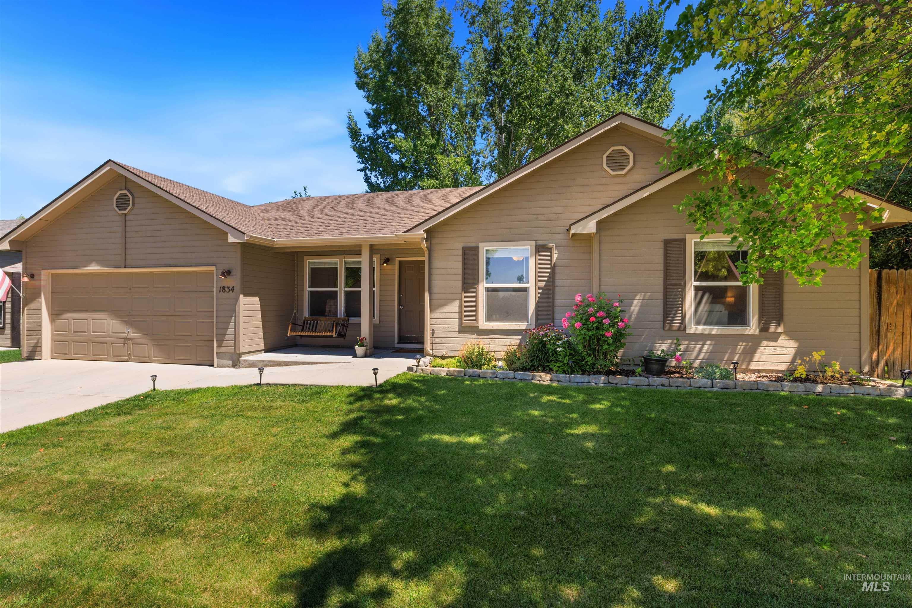 Ranch-style exterior with tan siding and dark brown shutters