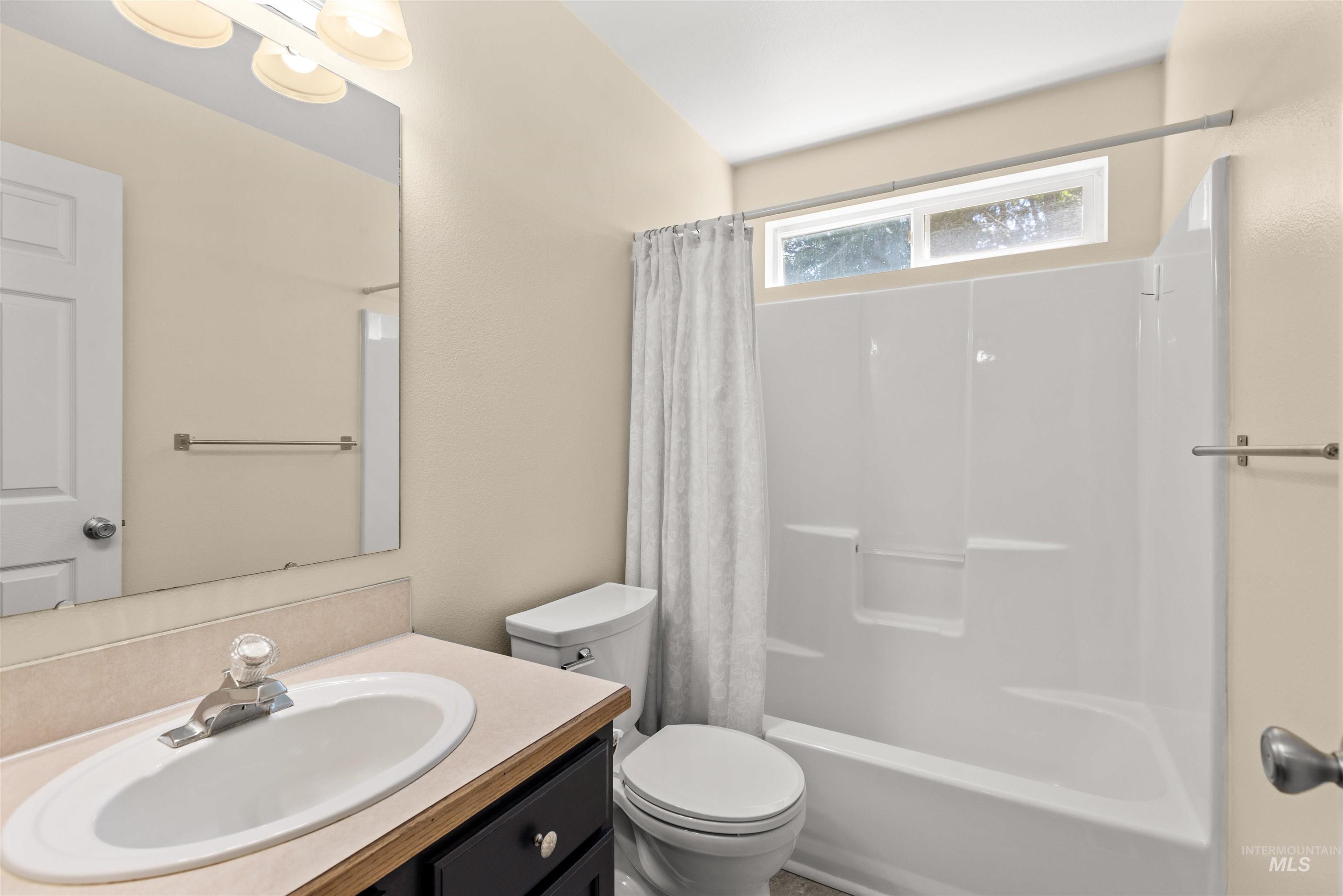 Bathroom featuring a single vanity with an oval sink, dark wood-finish cabinetry, and a light-colored countertop
