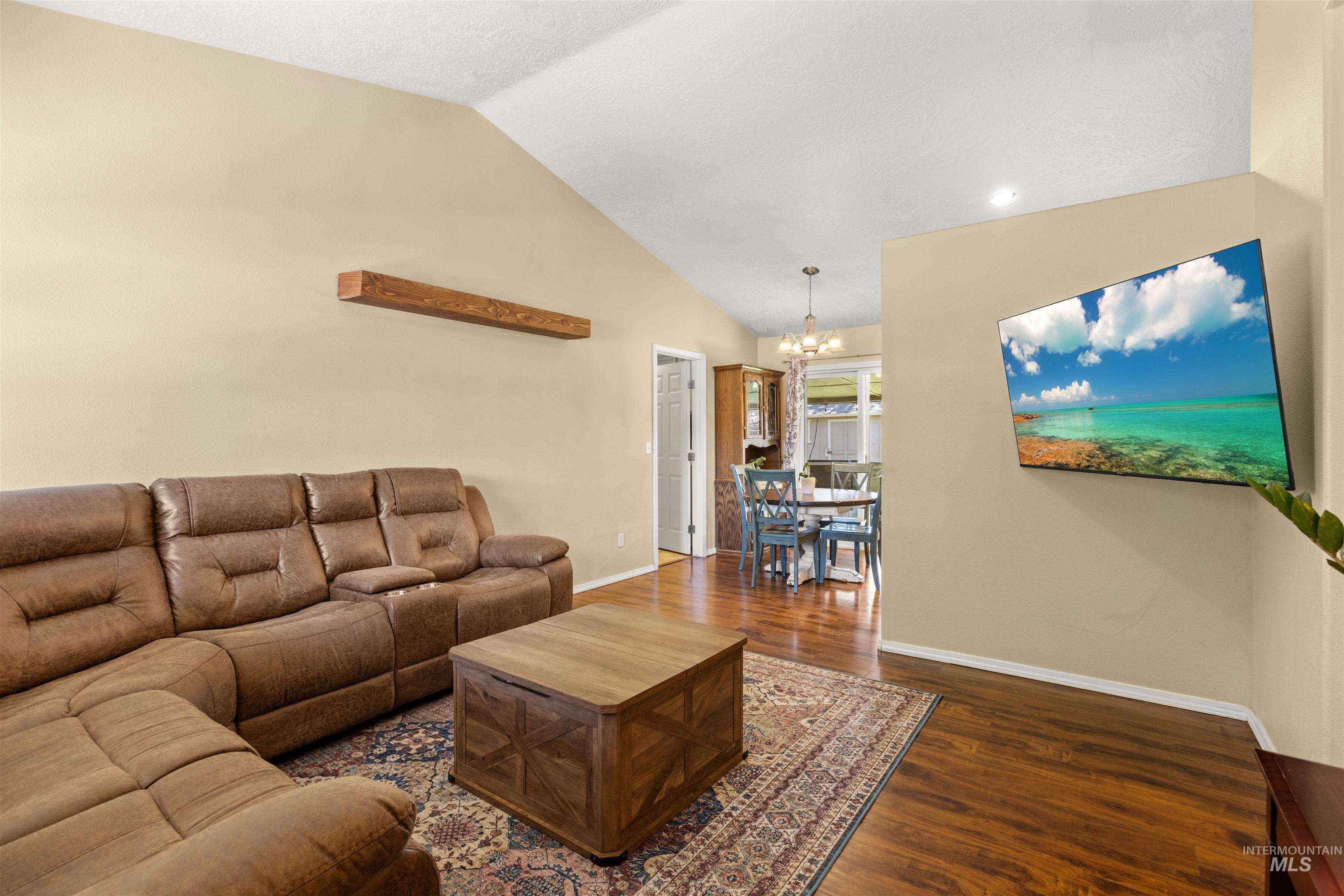 Spacious living area featuring vaulted ceilings and warm neutral wall tones