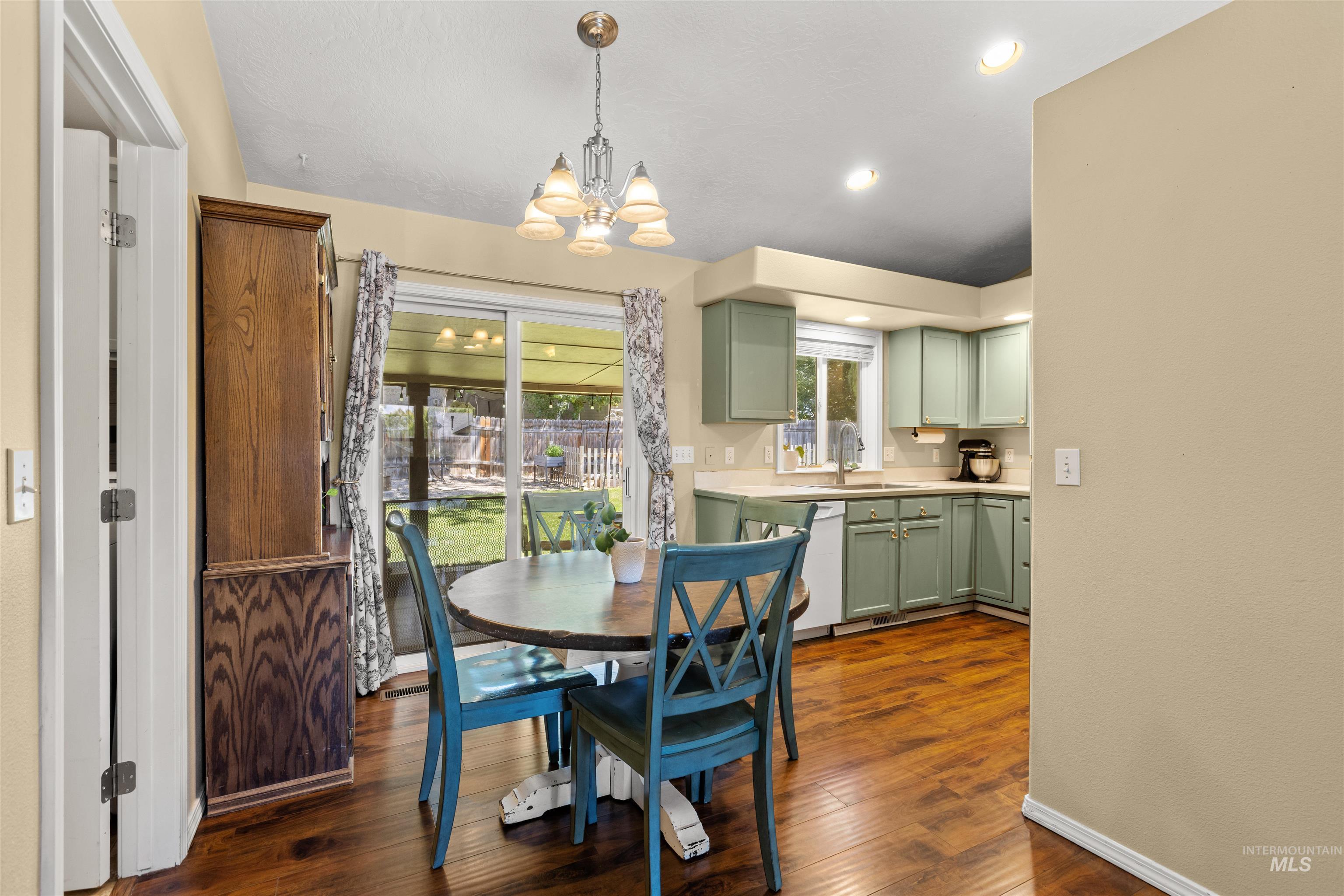 Kitchen and dining area featuring wood-finish flooring, recessed lighting, and a chandelier