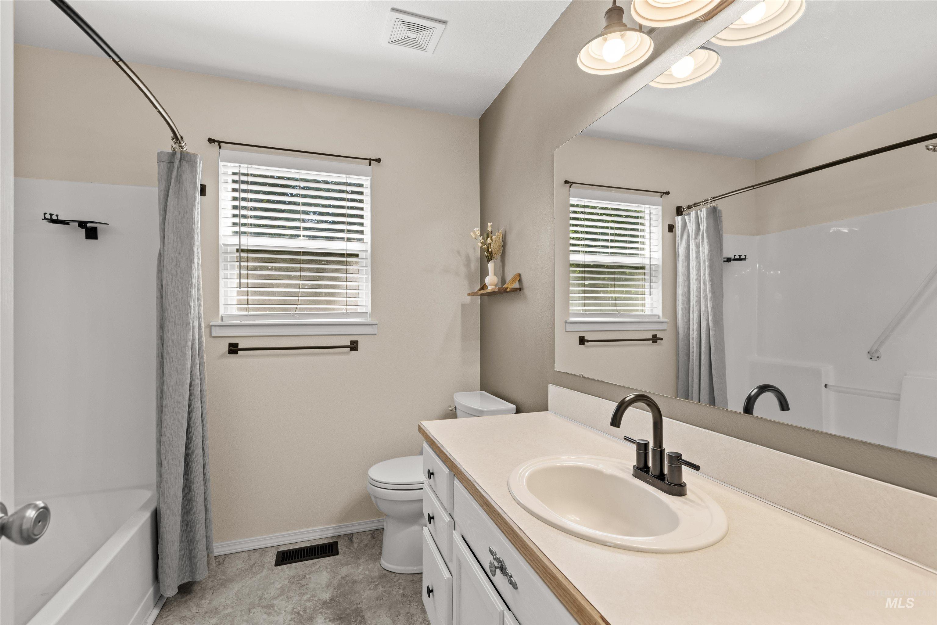 Bathroom with a white vanity featuring a single basin sink and a dark bronze faucet