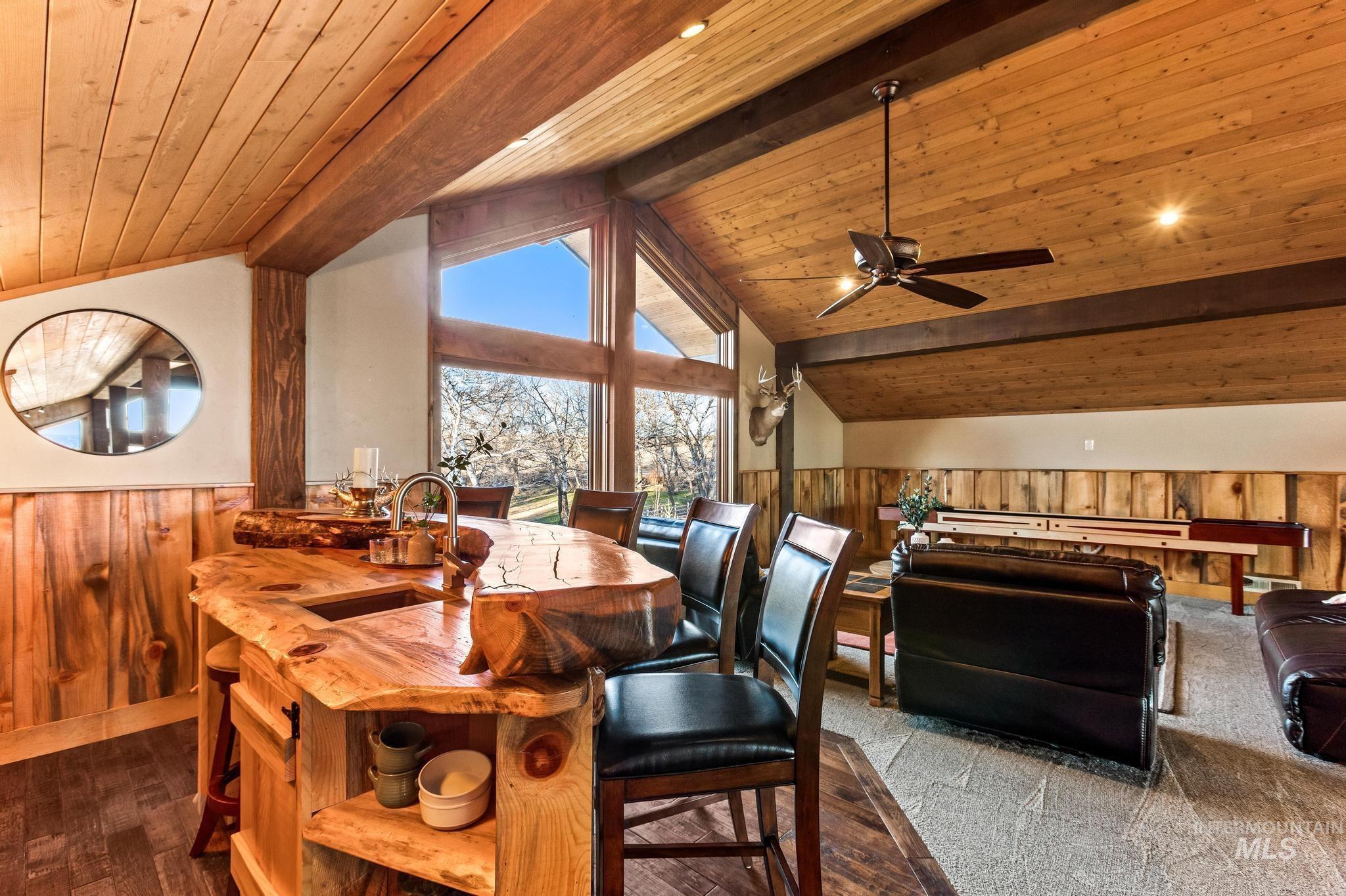 Upstairs loft with Custom Milled bar with sink, rustic wainscoted walls, exposed beams with tongue and groove wood ceiling, abundant windows & open to great room below