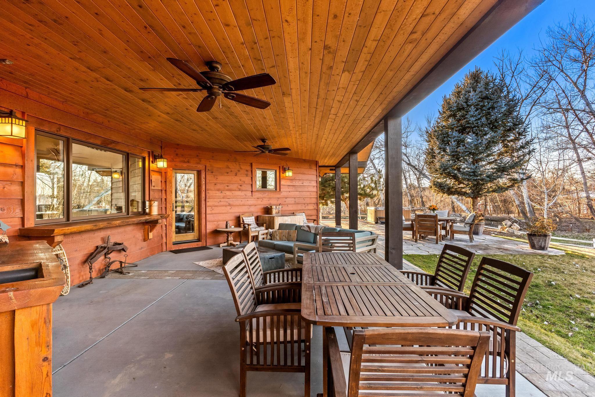 View of patio & terrace with an outdoor living , hot tub and large lawn area