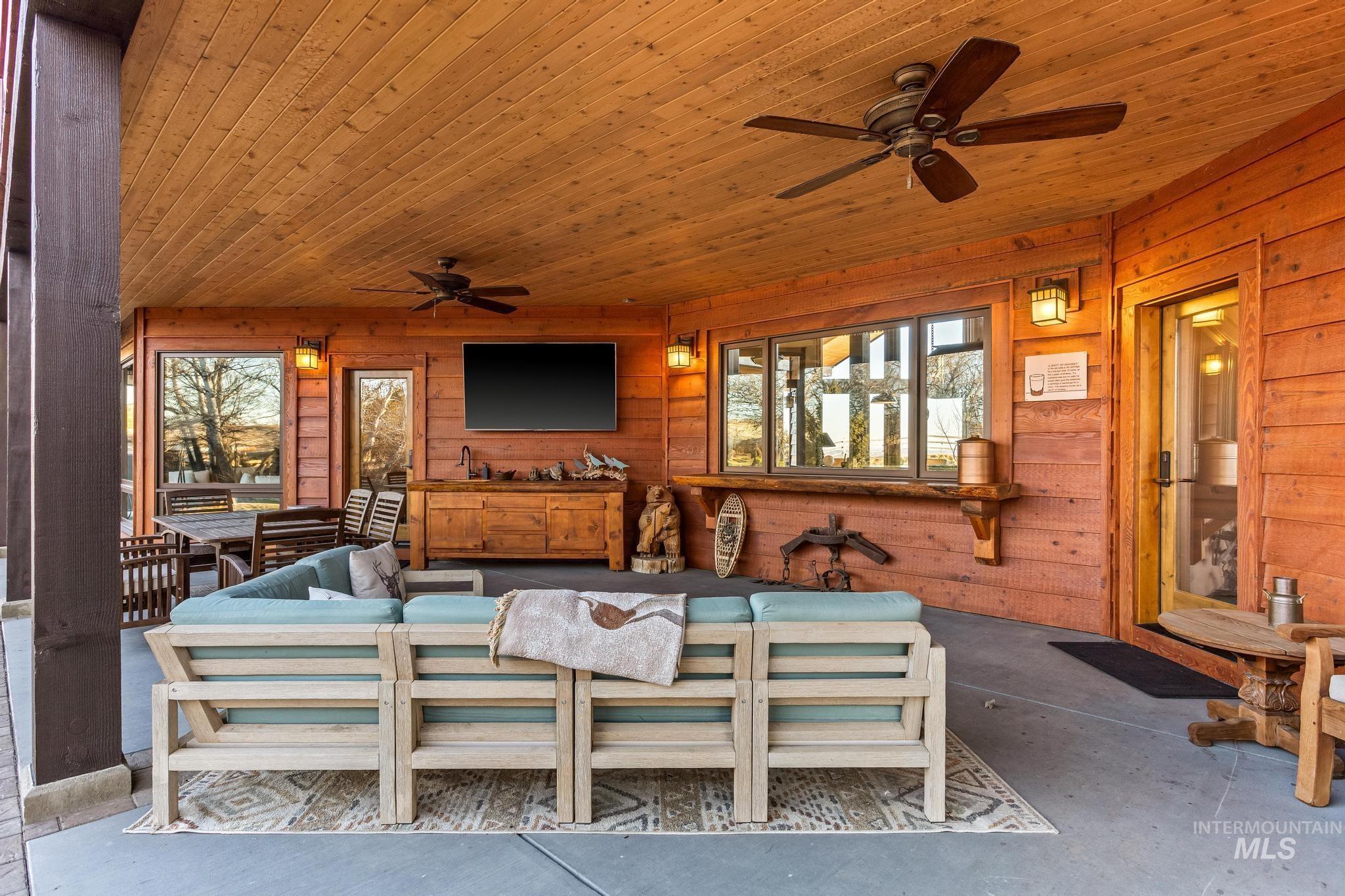 Extensive Patio with custom built-in bar with sink and extensive space for entertaining.  Wood paneled ceilings with two ceiling fans and multiple access points into home