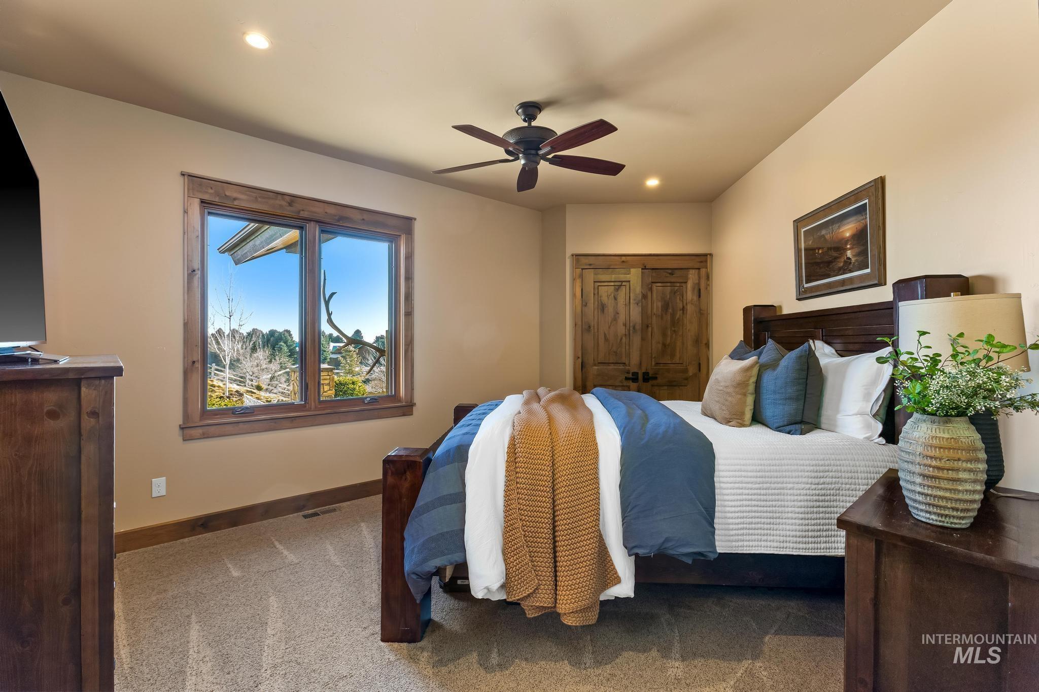 Bedroom featuring it's own ensuite, ceiling fan, recessed lighting, and ample natural light