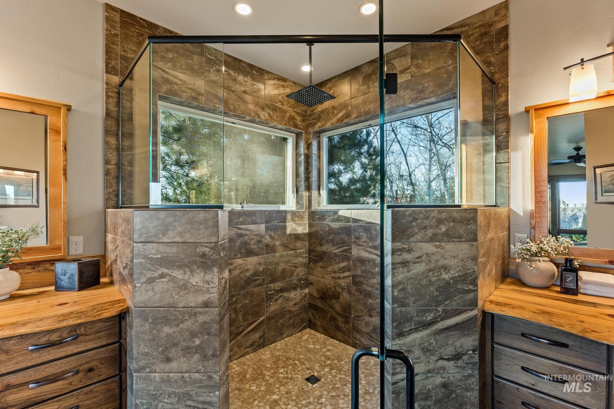 Large Walk-in shower with glass door, large windows, dual vanities, custom tile work