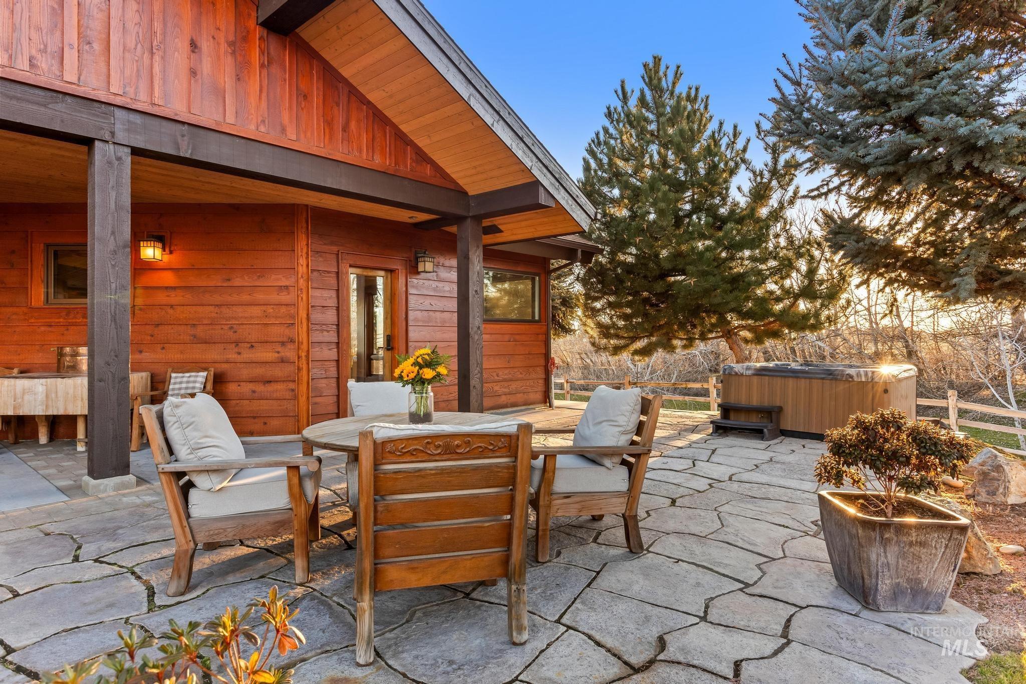View of patio with a hot tub and outdoor dining area