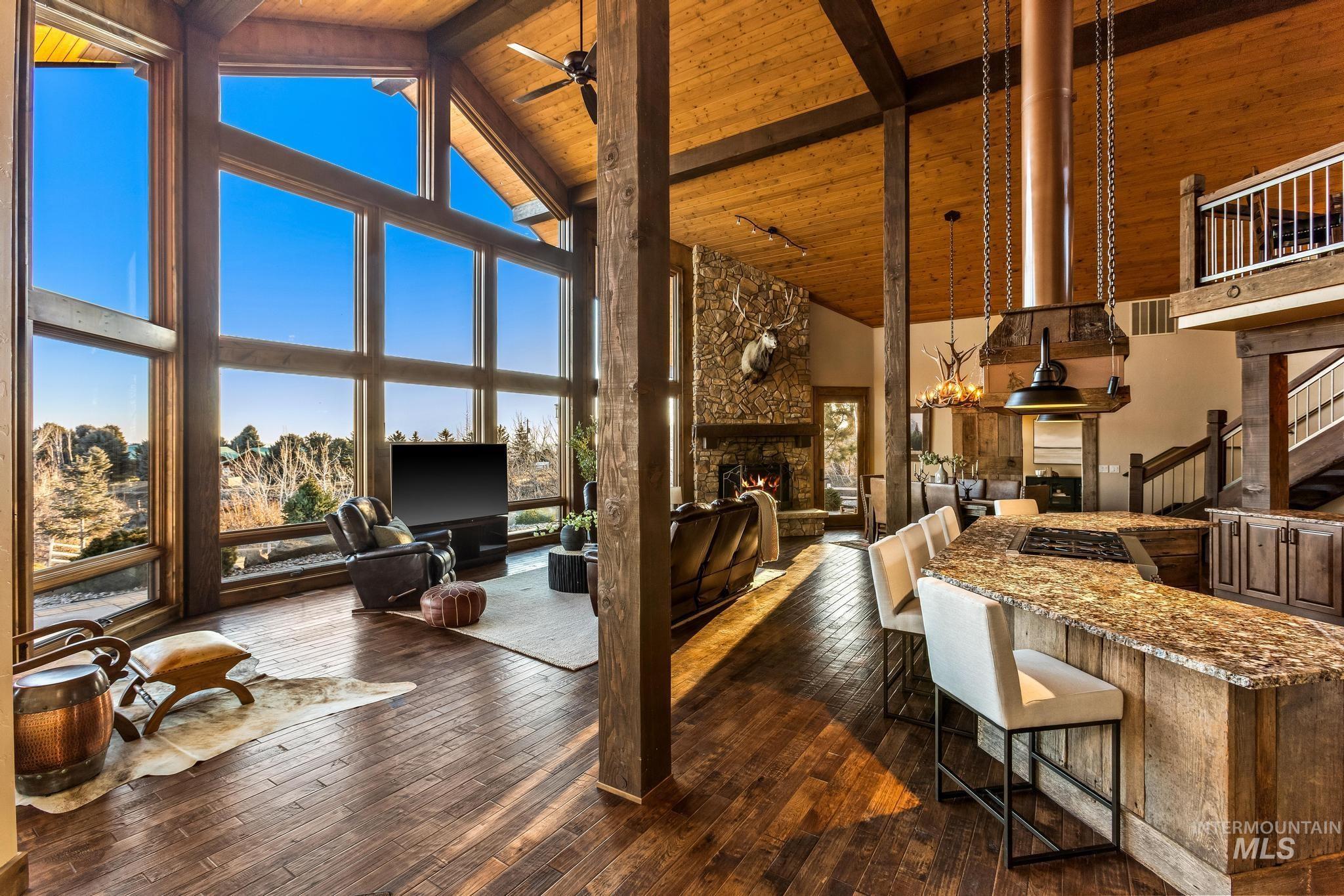Great Room with wall of windows, beamed, tongue-and groove wood ceiling and floor to ceiling stone fireplace